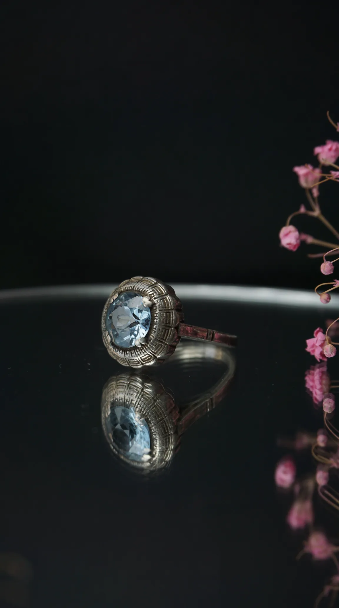 Vintage silver ring with round light blue aquamarine gemstone and intricate patterned setting