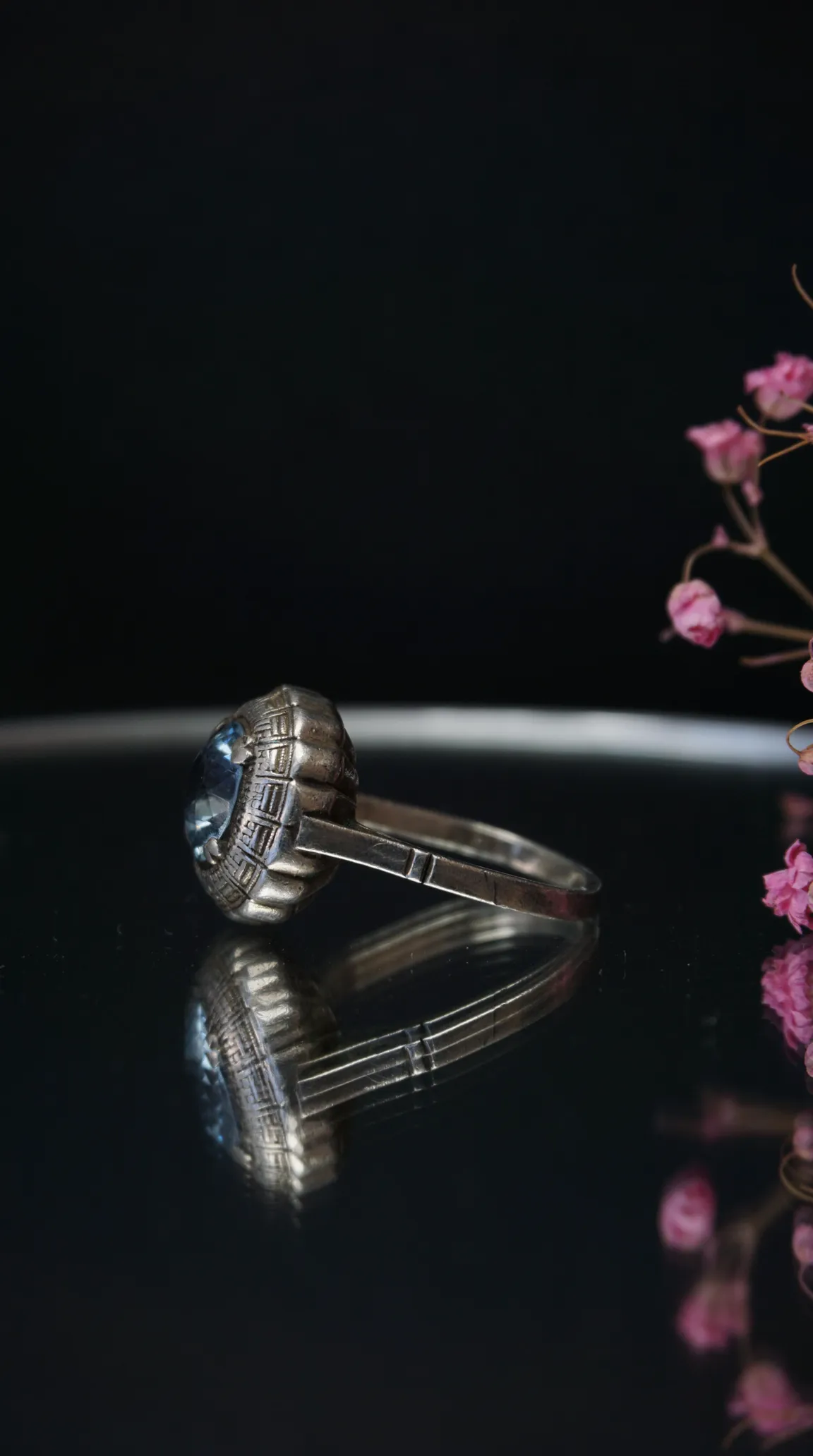 Vintage silver ring with light blue gemstone and intricate Art Deco setting.