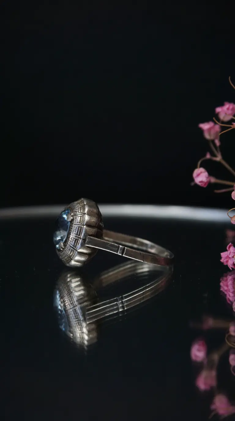 Vintage silver ring with light blue gemstone and intricate Art Deco setting.