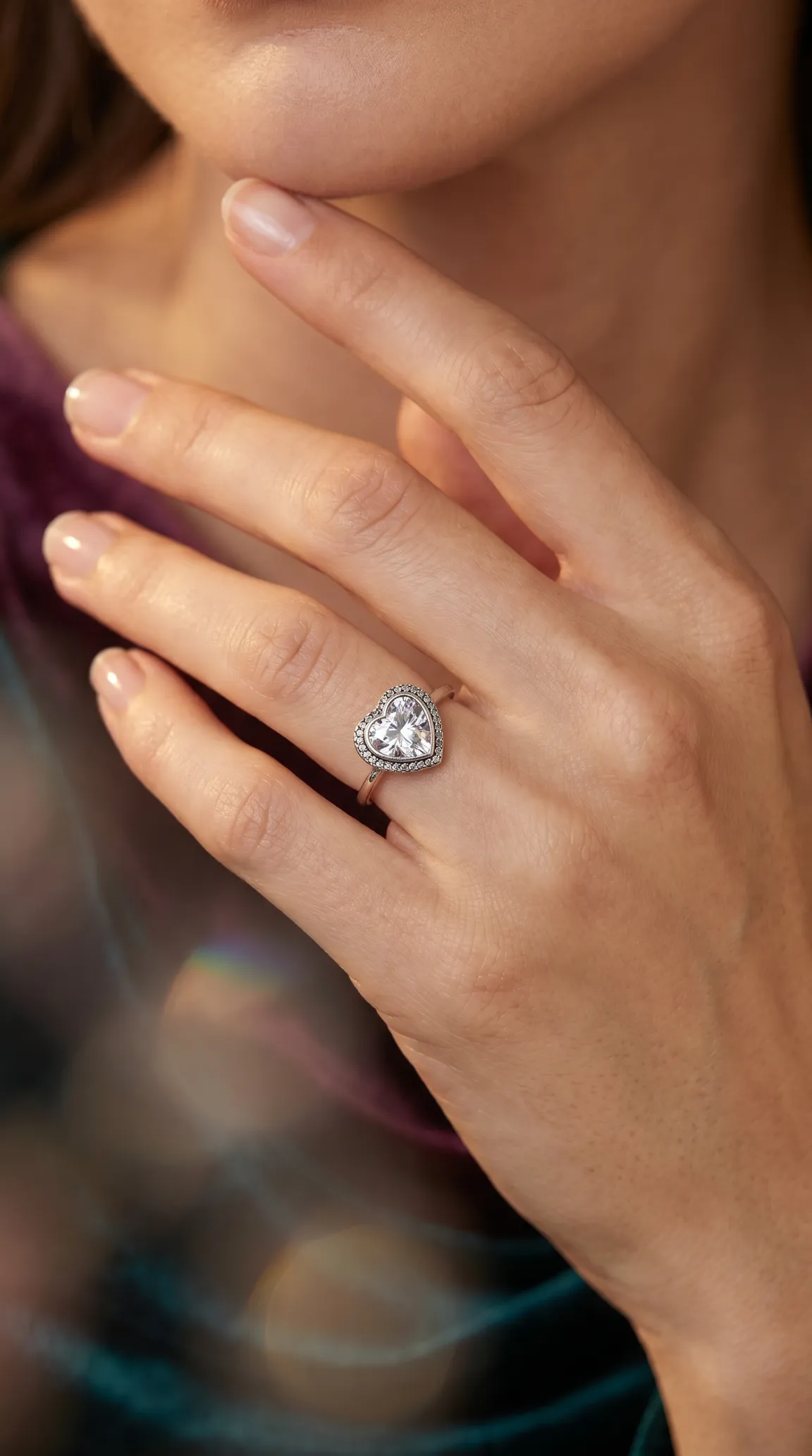 Vintage heart-shaped diamond ring with halo setting on a woman's hand.