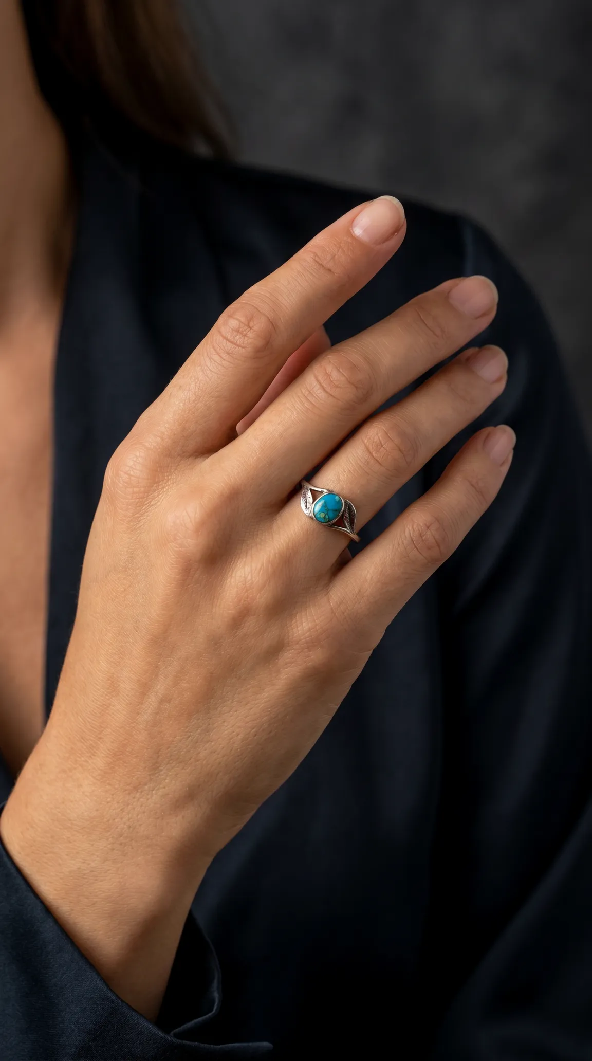 Vintage sterling silver oval turquoise ring with leaf design worn on hand
