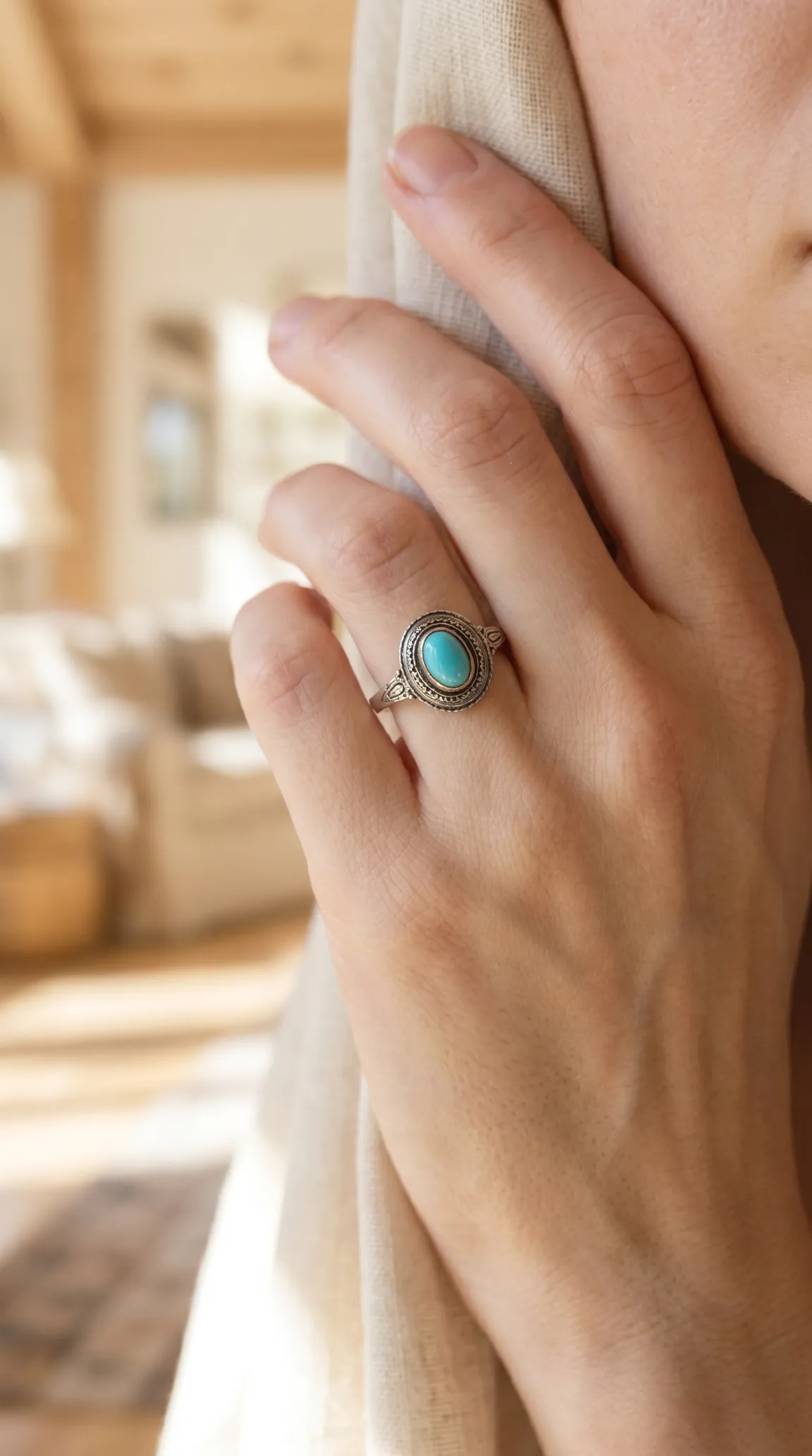 Vintage silver ring with oval turquoise gemstone, intricate filigree detail, worn on a hand