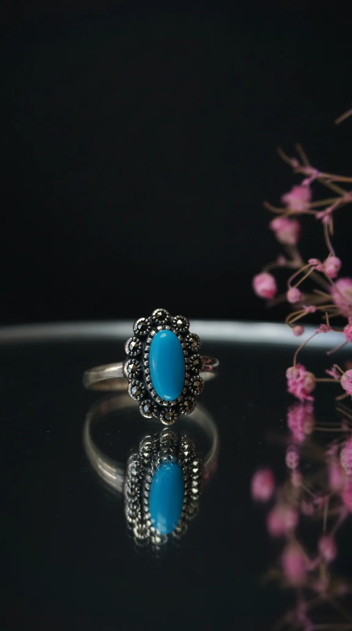 Vintage sterling silver ring with oval turquoise gemstone and marcasite accents.