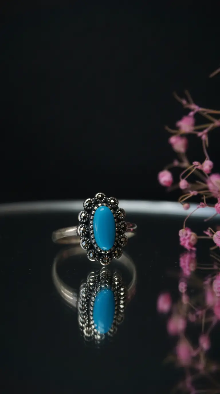 Vintage sterling silver ring with oval turquoise gemstone and marcasite accents.