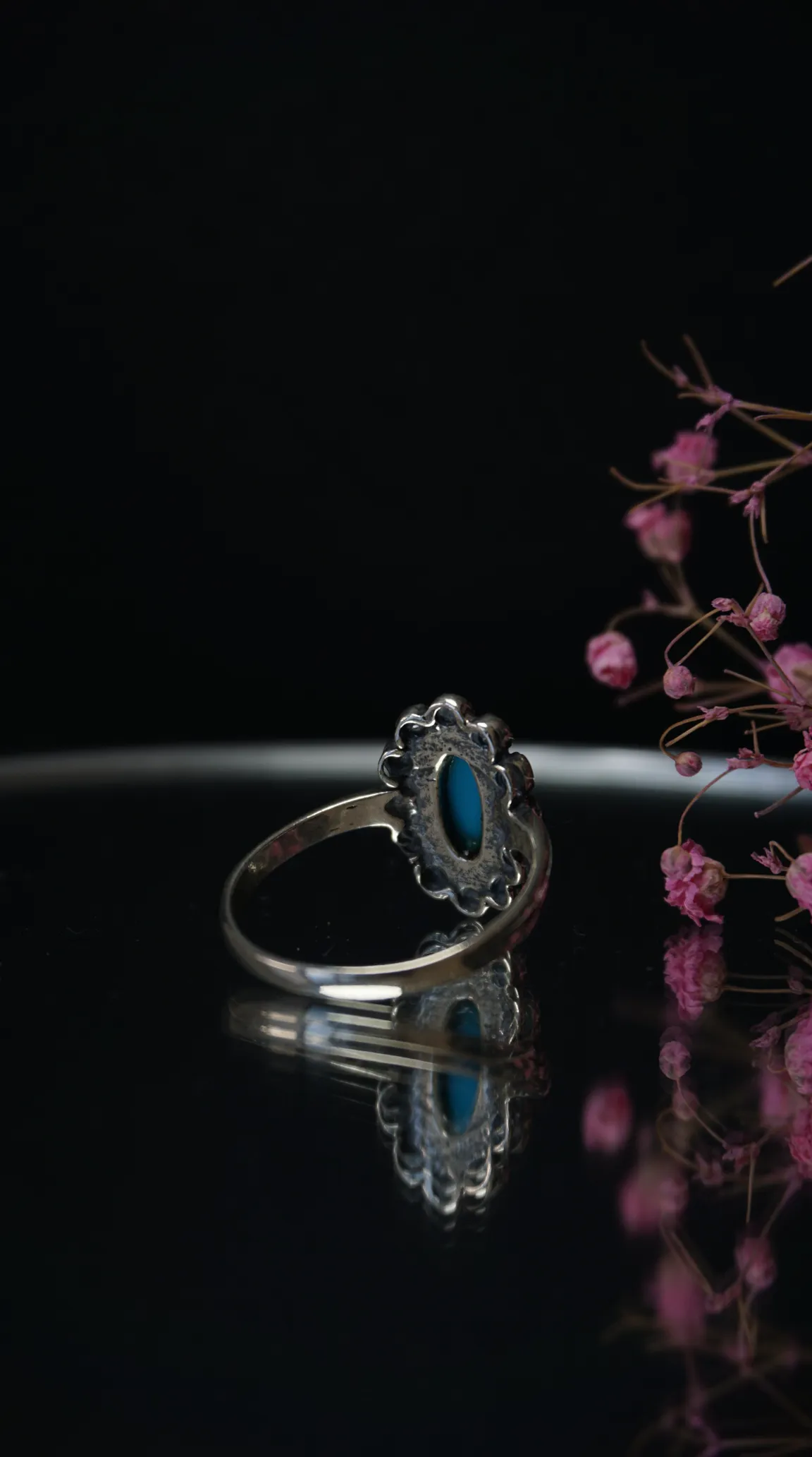 Vintage silver ring with oval turquoise gemstone and ornate scalloped setting.