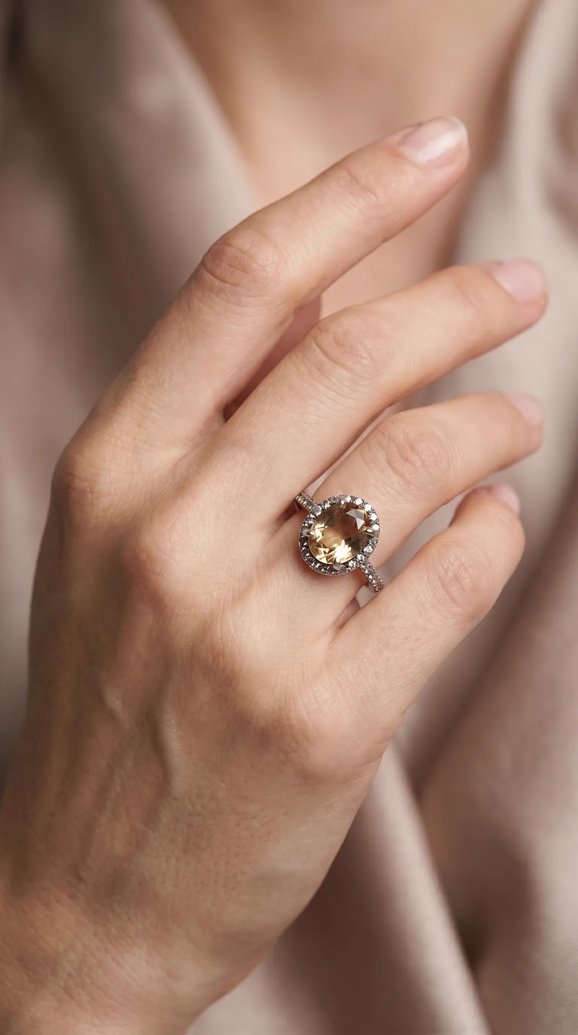 Vintage oval champagne citrine halo ring with diamond accents on a white gold band, worn on a hand.