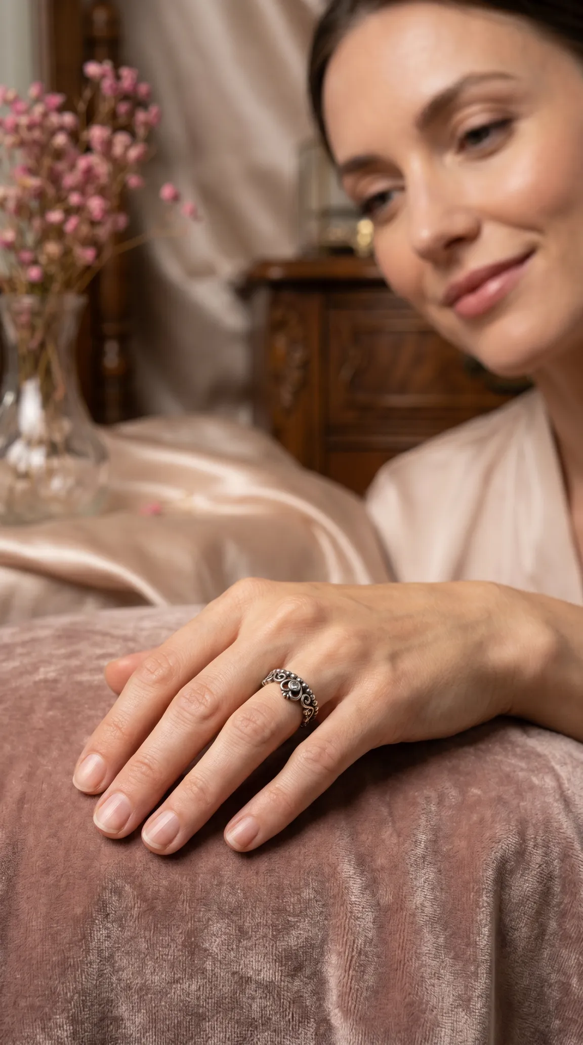 Vintage filigree ring with clear gemstone on woman's hand, showcasing intricate antique jewelry design.