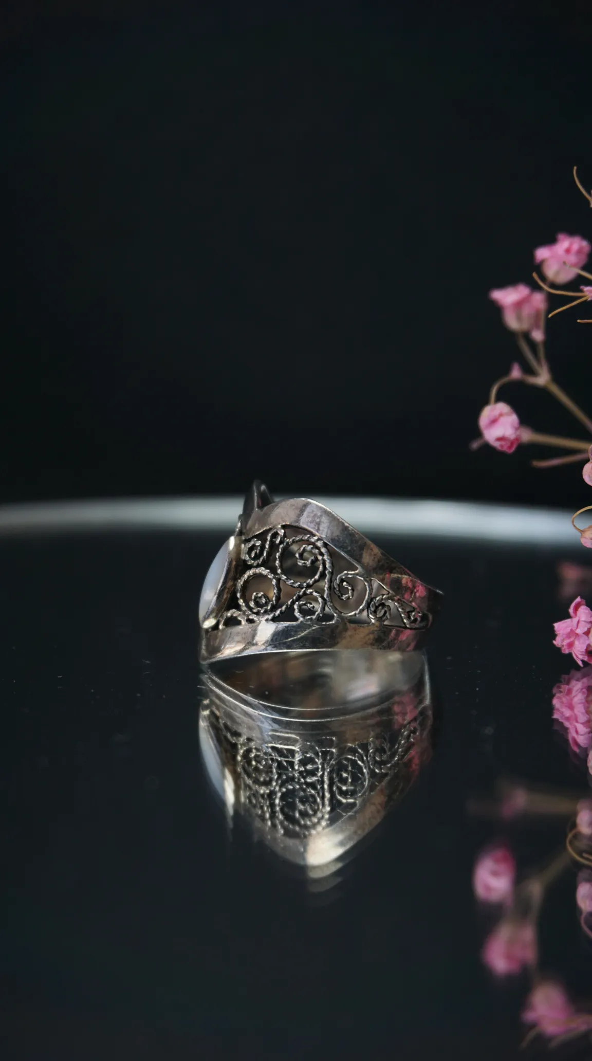 Vintage silver filigree ring with intricate scrollwork and white gemstone