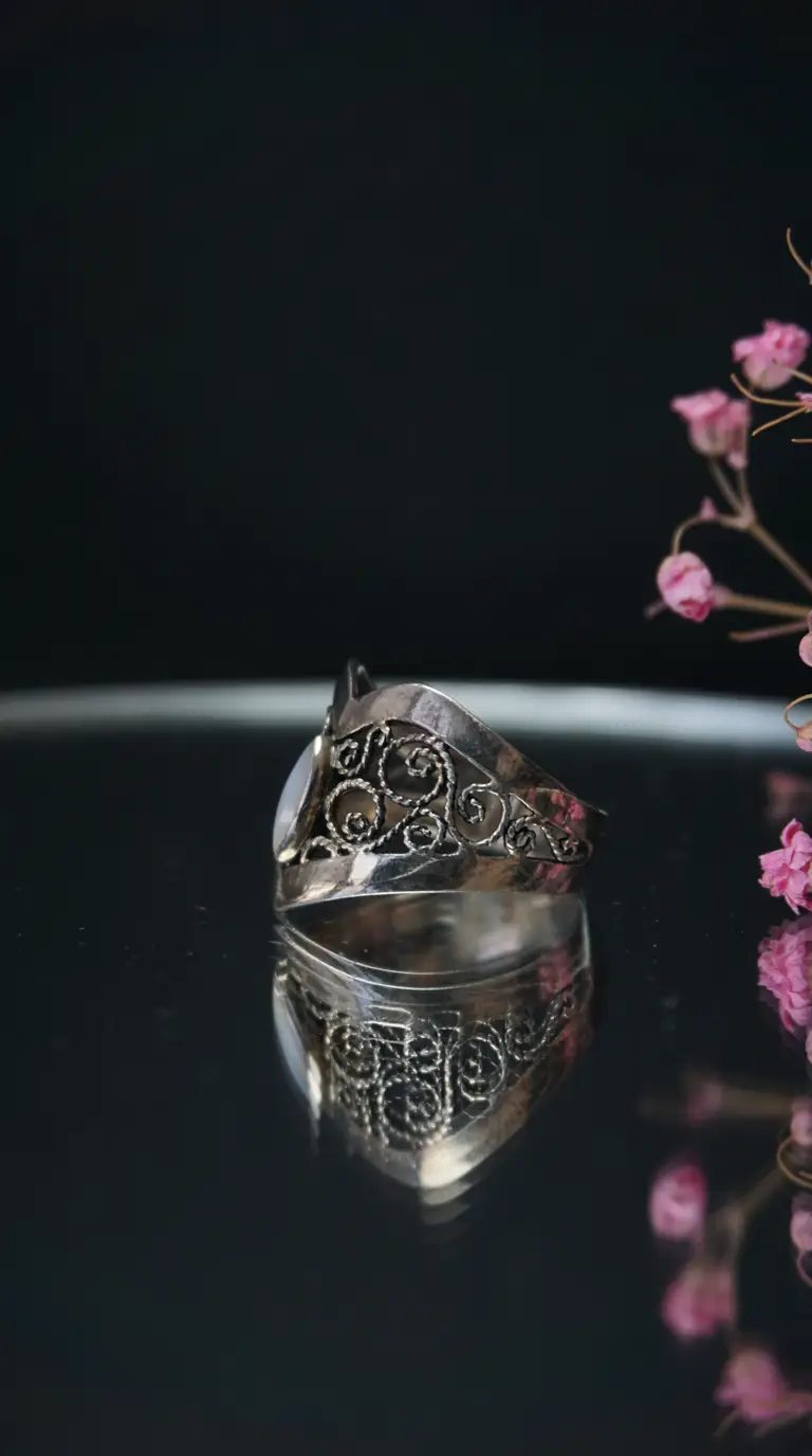 Vintage silver filigree ring with intricate scrollwork and white gemstone