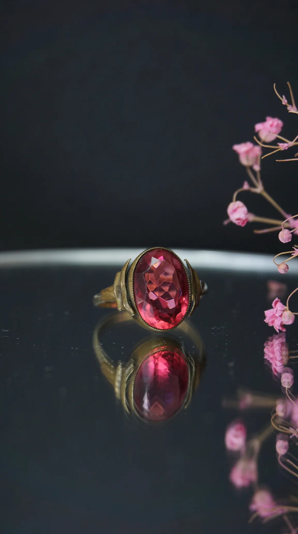 Vintage gold-tone ring with oval faceted pink gemstone.