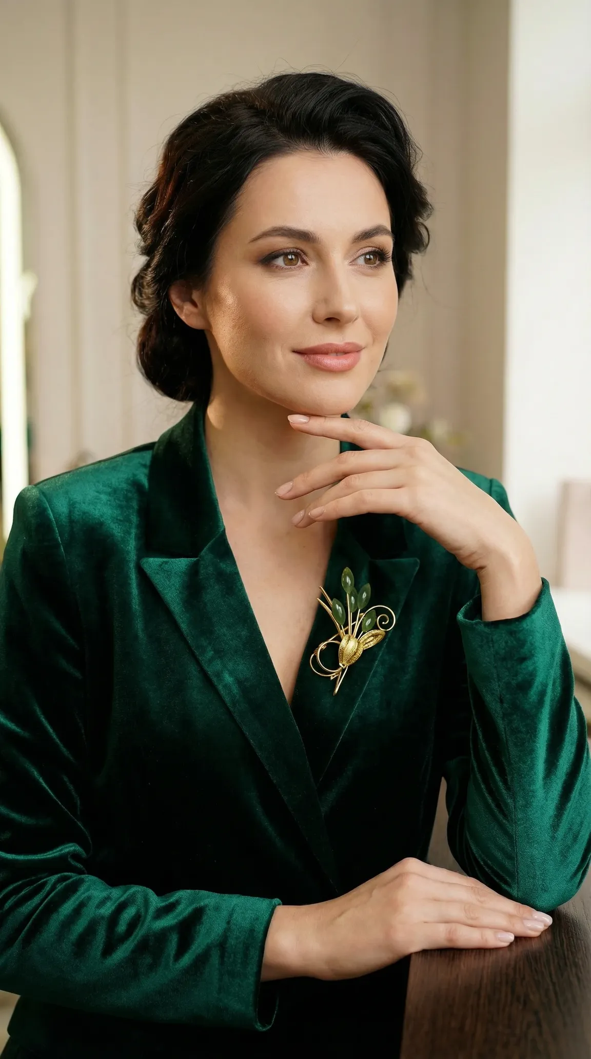 Vintage gold and green gemstone floral brooch on an elegant woman's emerald velvet blazer.