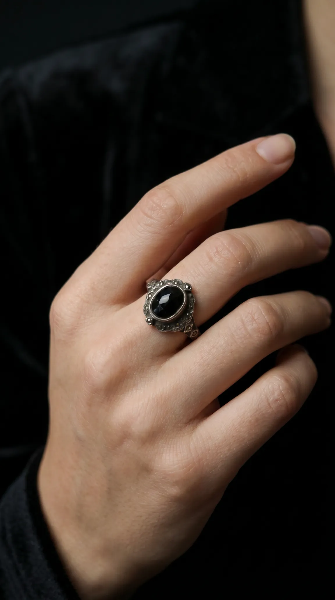 Vintage sterling silver black onyx ring with marcasite details worn on a hand