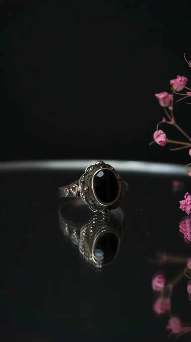 Vintage silver ring with oval black onyx gemstone and marcasite accents.