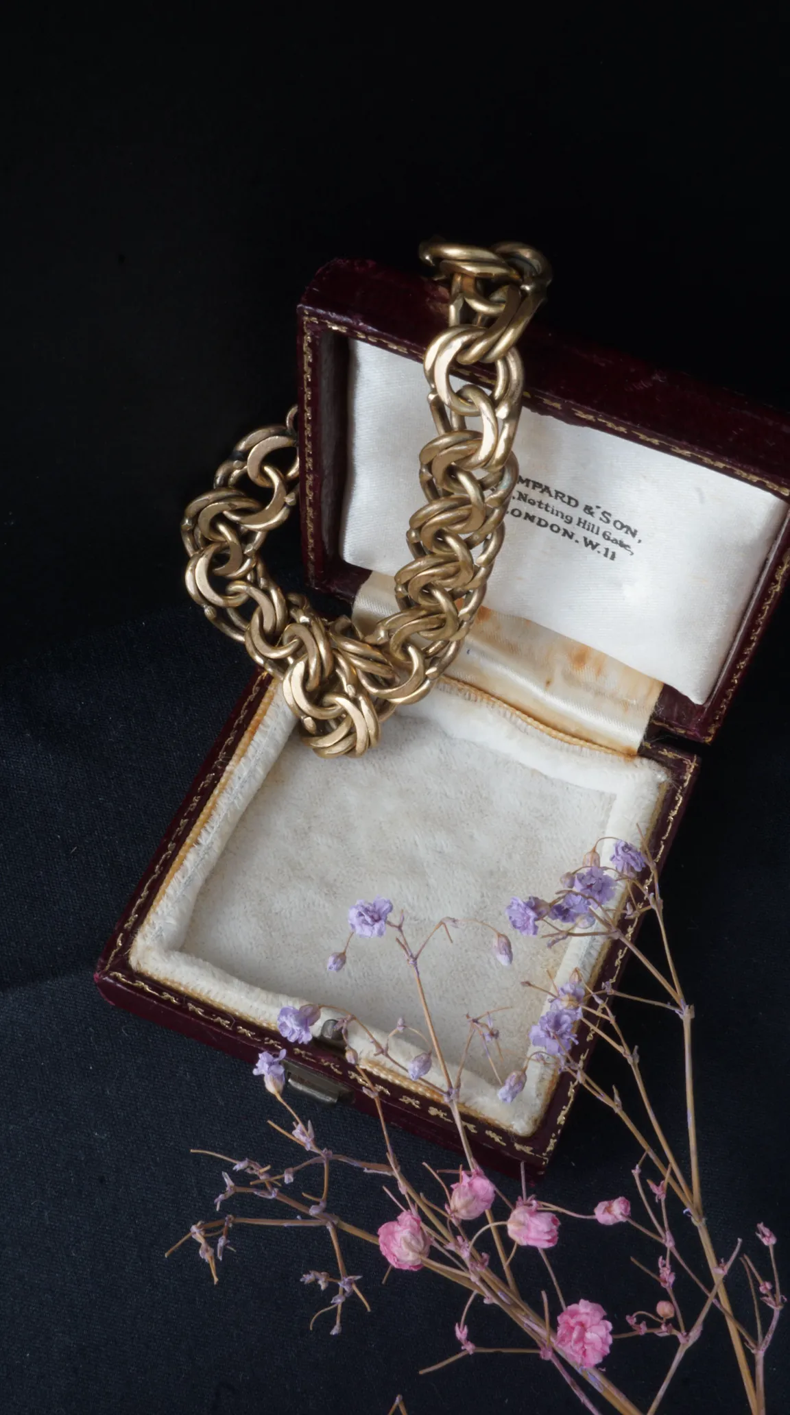 Vintage gold chunky chain bracelet in open red leather BAMPARD & SON Notting Hill Gate London jewelry box with dried purple flowers.