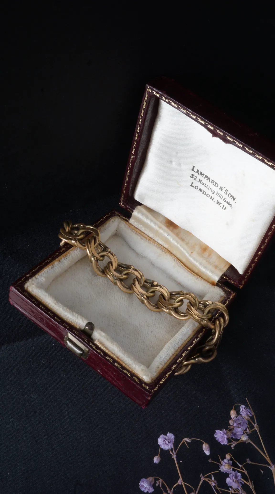 Vintage gold tone chain link bracelet in open antique red Lampard & Son jewelry box, London.