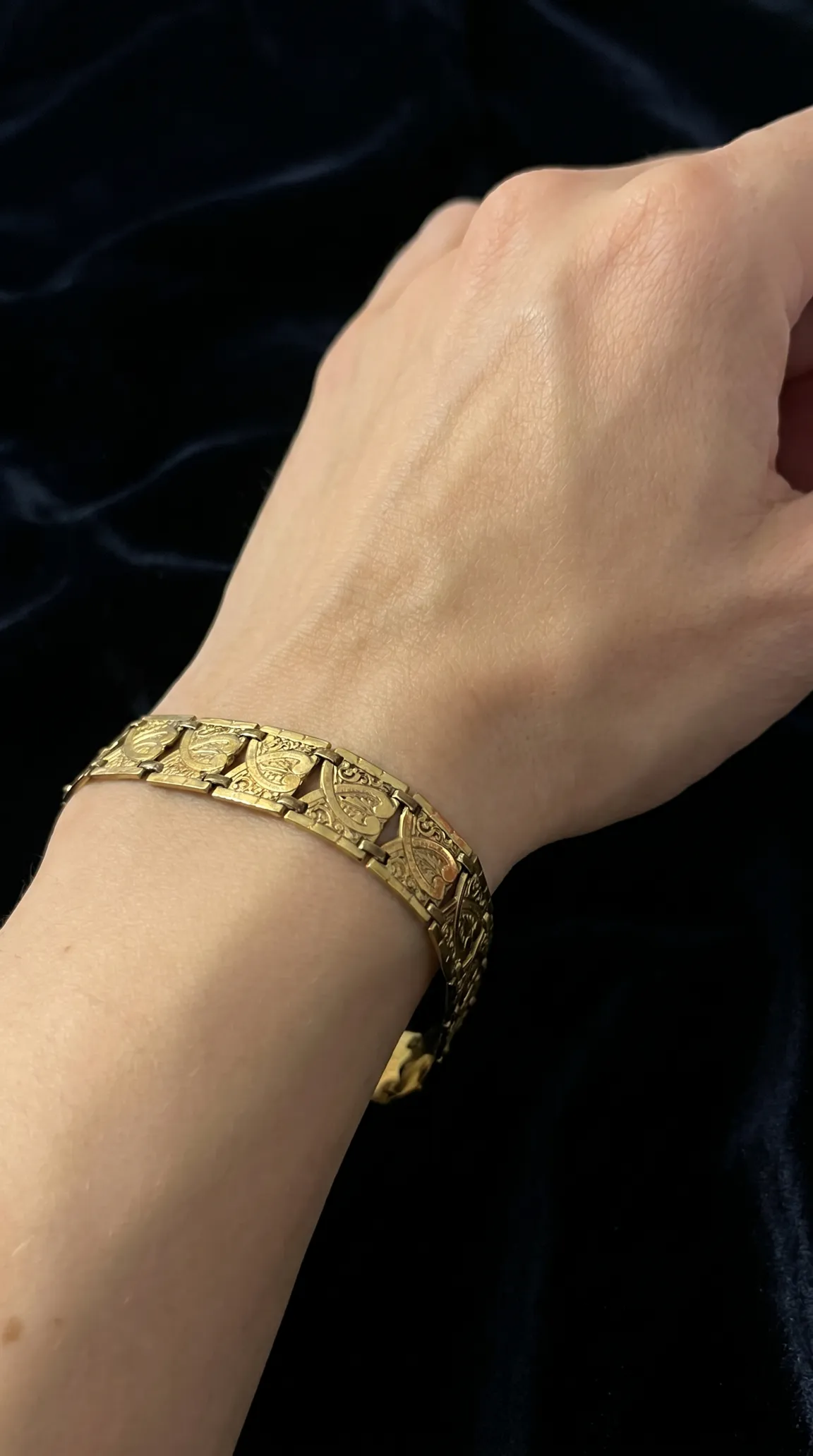 Vintage ornate etched gold link bracelet on a woman's wrist