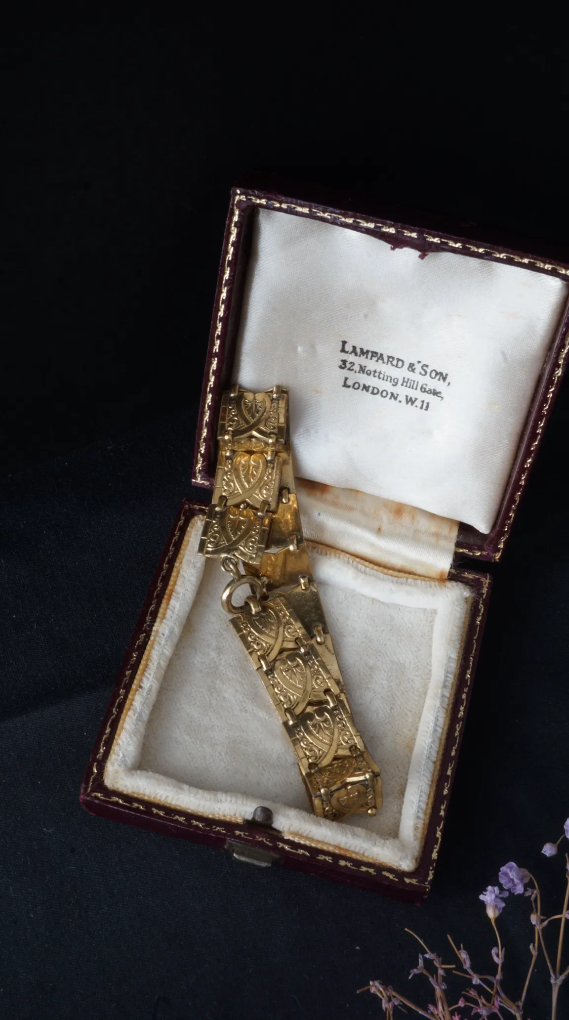 Antique gold ornate link bracelet with engraved detail in vintage burgundy velvet Lampard & Son jewelry box.