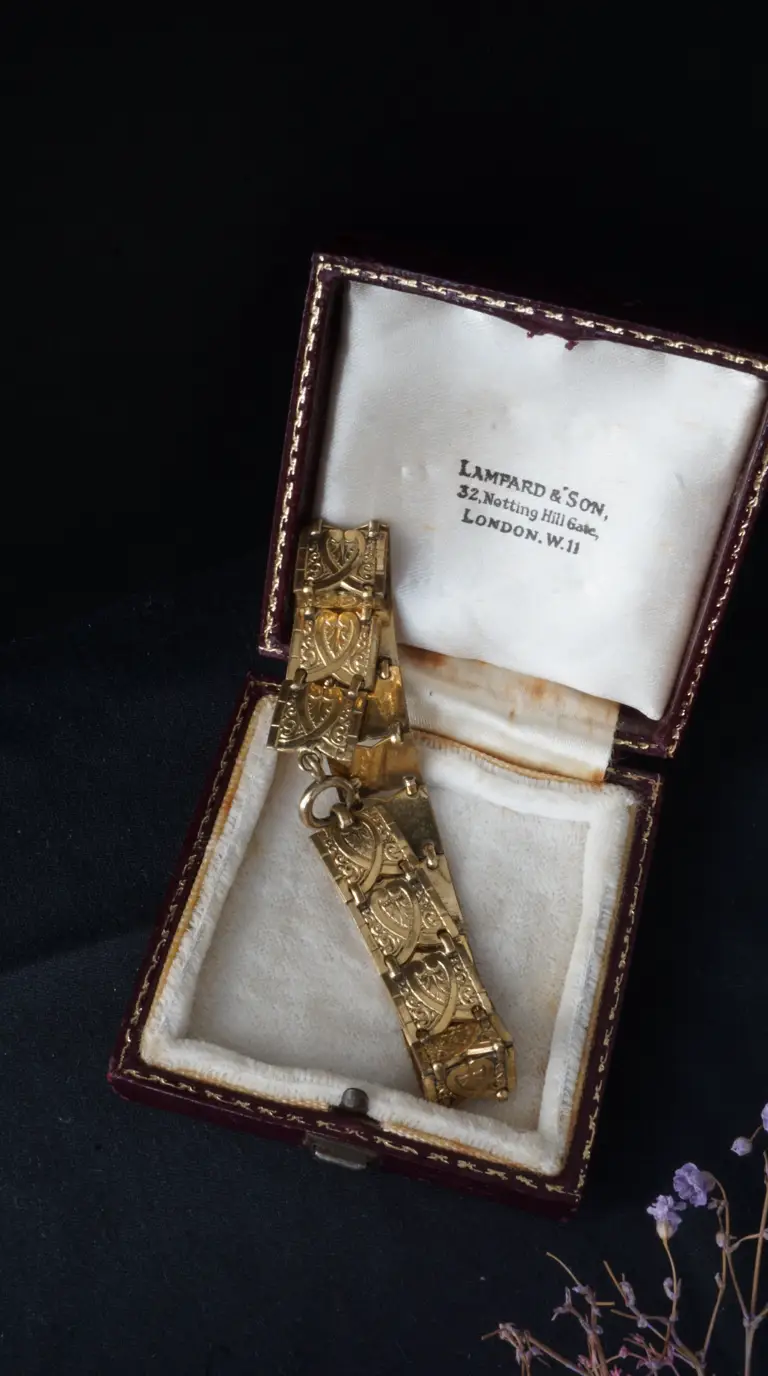 Antique gold ornate link bracelet with engraved detail in vintage burgundy velvet Lampard & Son jewelry box.