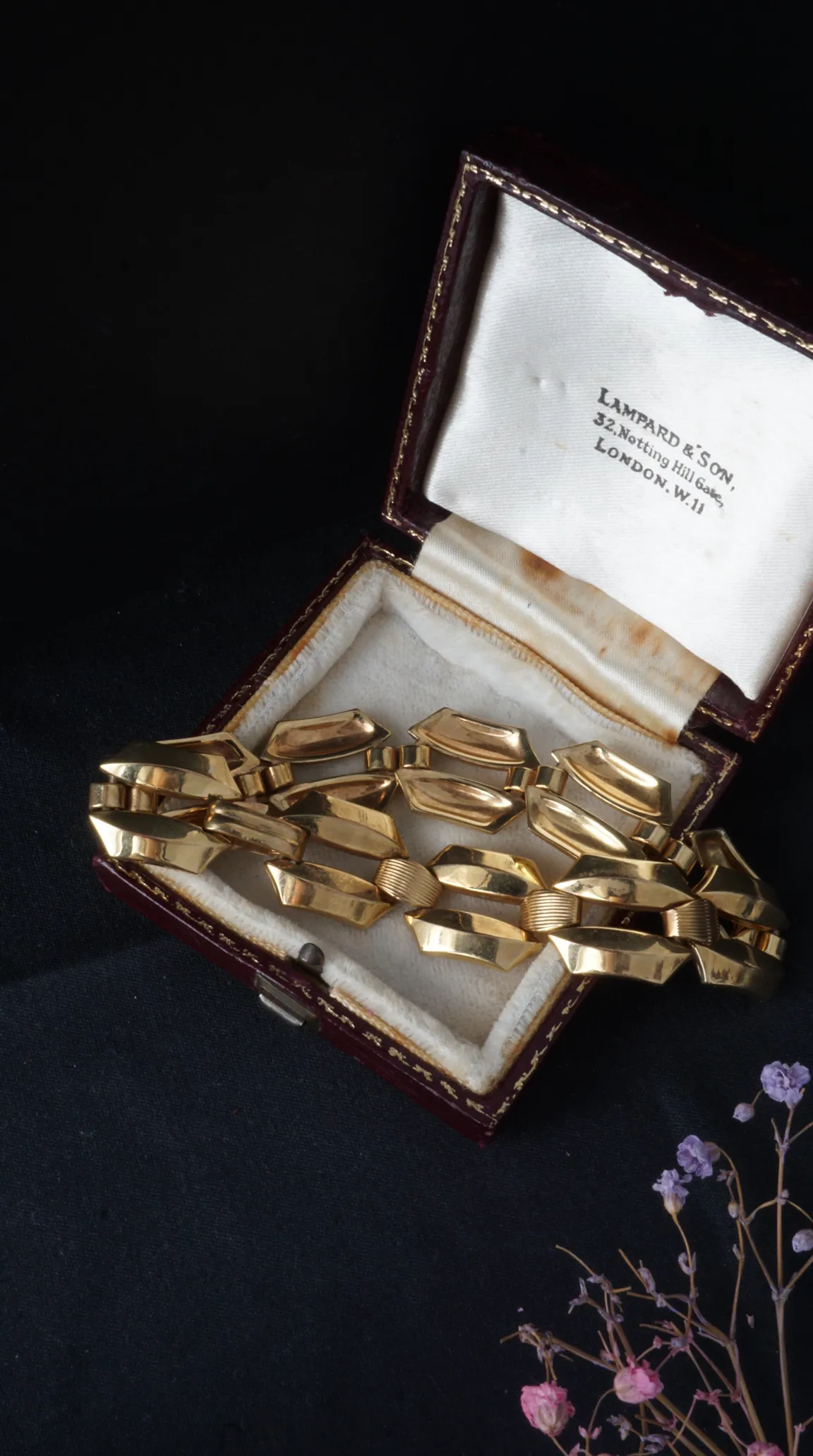 Vintage yellow gold bracelet with geometric and ribbed links inside an antique Lampard & Son jewelry box.