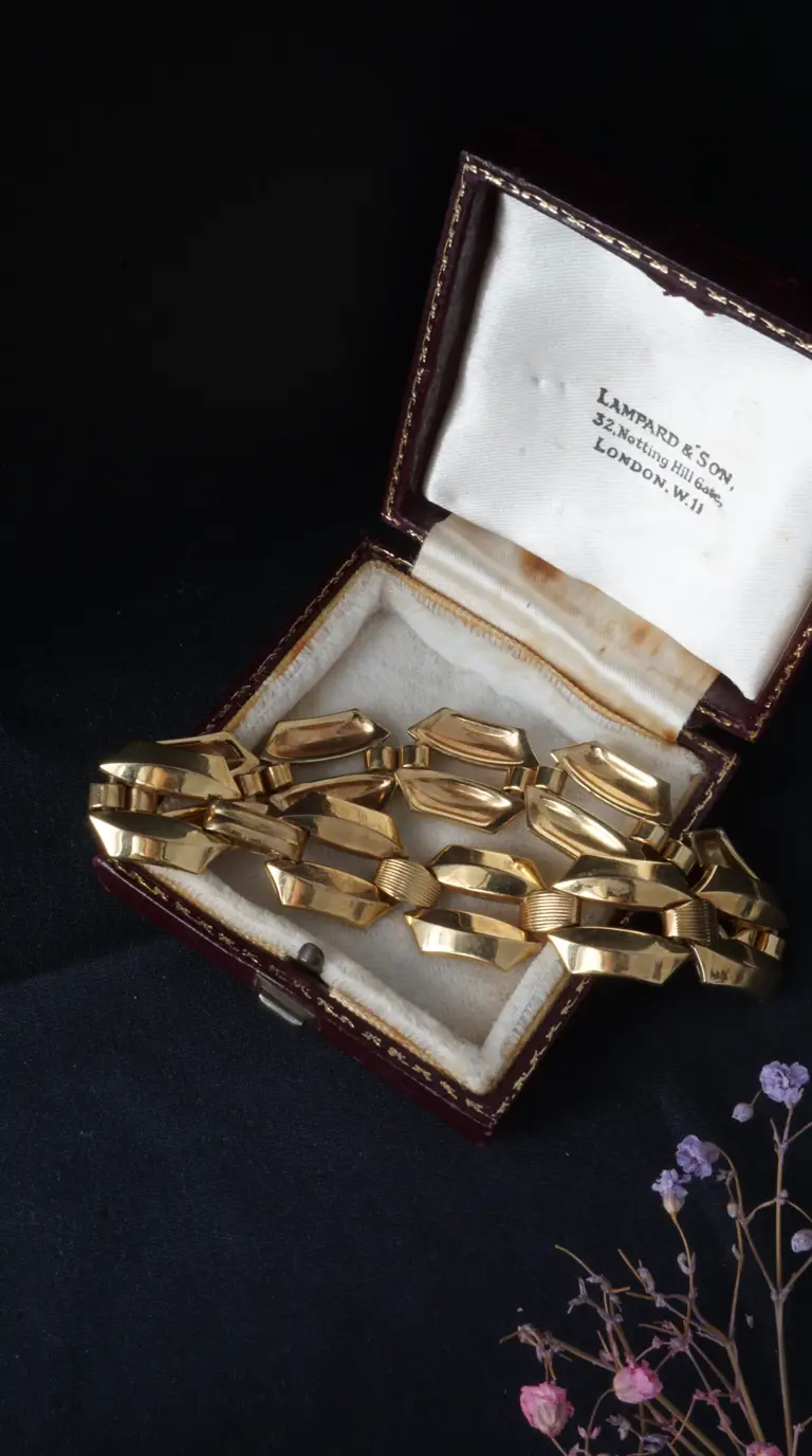 Vintage yellow gold bracelet with geometric and ribbed links inside an antique Lampard & Son jewelry box.