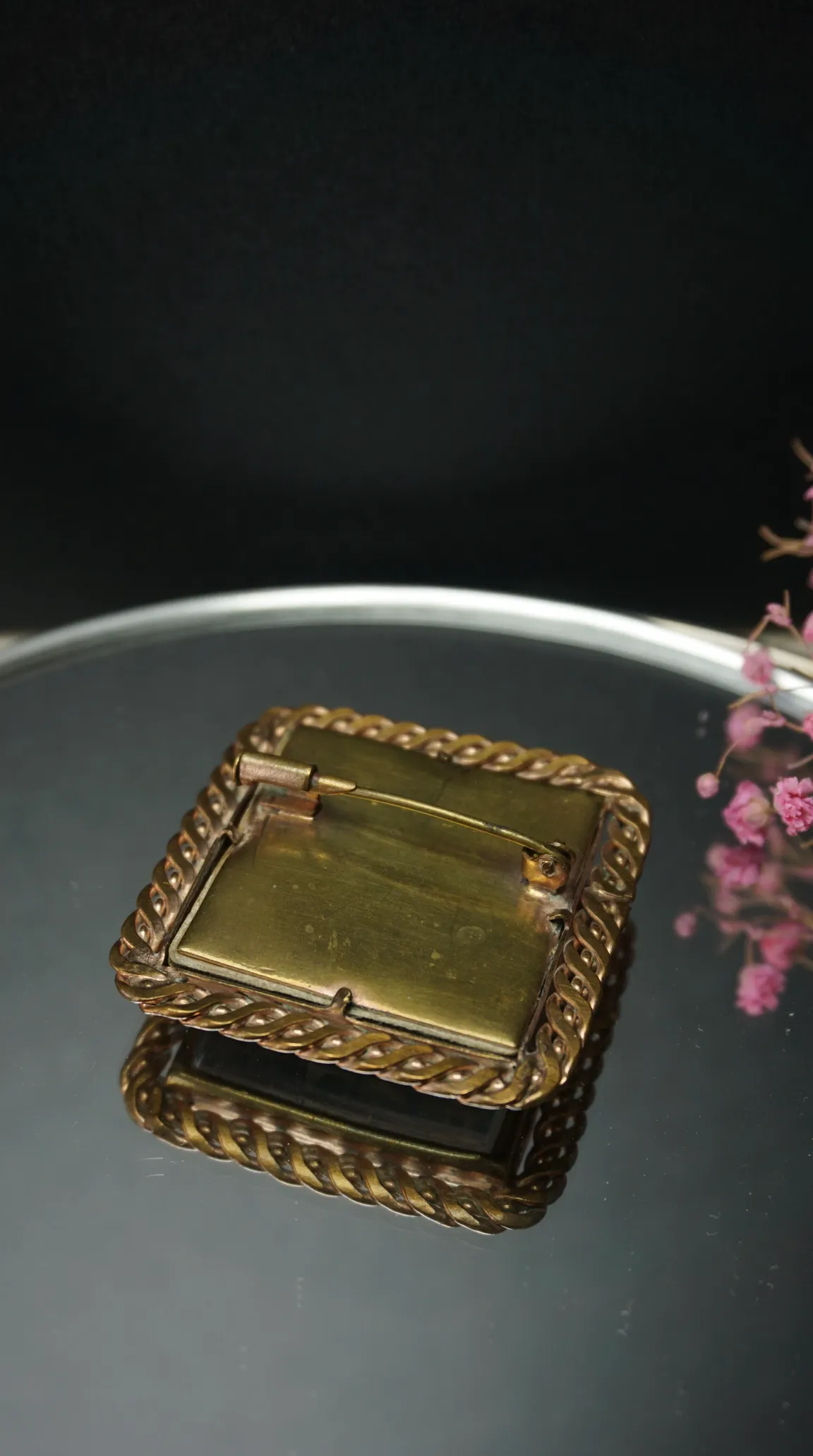 Vintage brass rectangular brooch back with twisted rope border and pin mechanism.