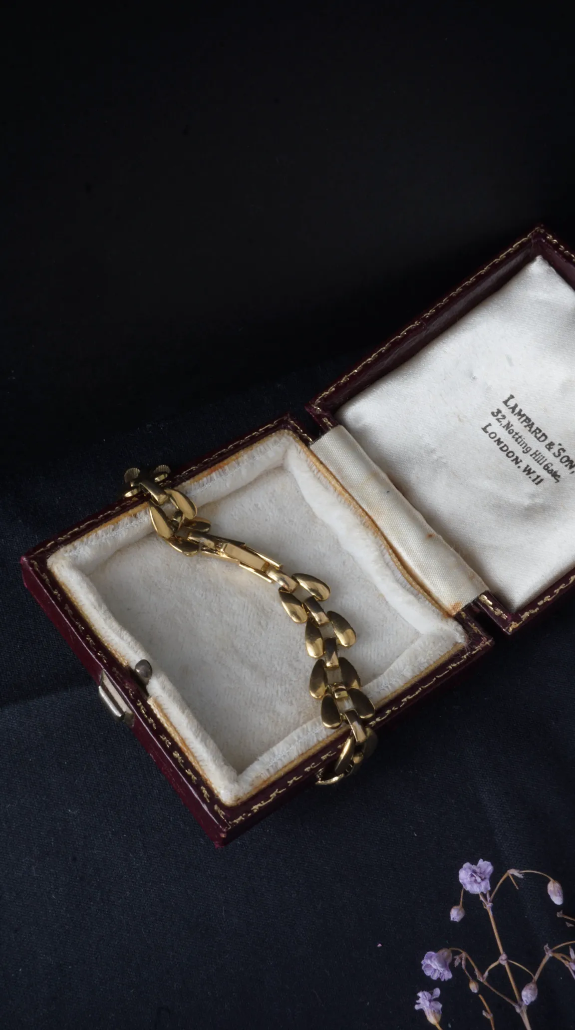 Vintage gold bracelet with flat links in open Lampard & Son London jewelry box.