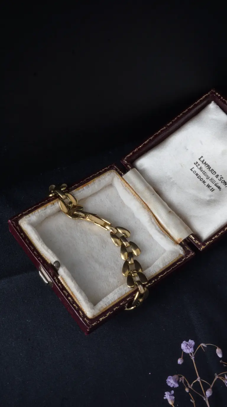 Vintage gold bracelet with flat links in open Lampard & Son London jewelry box.