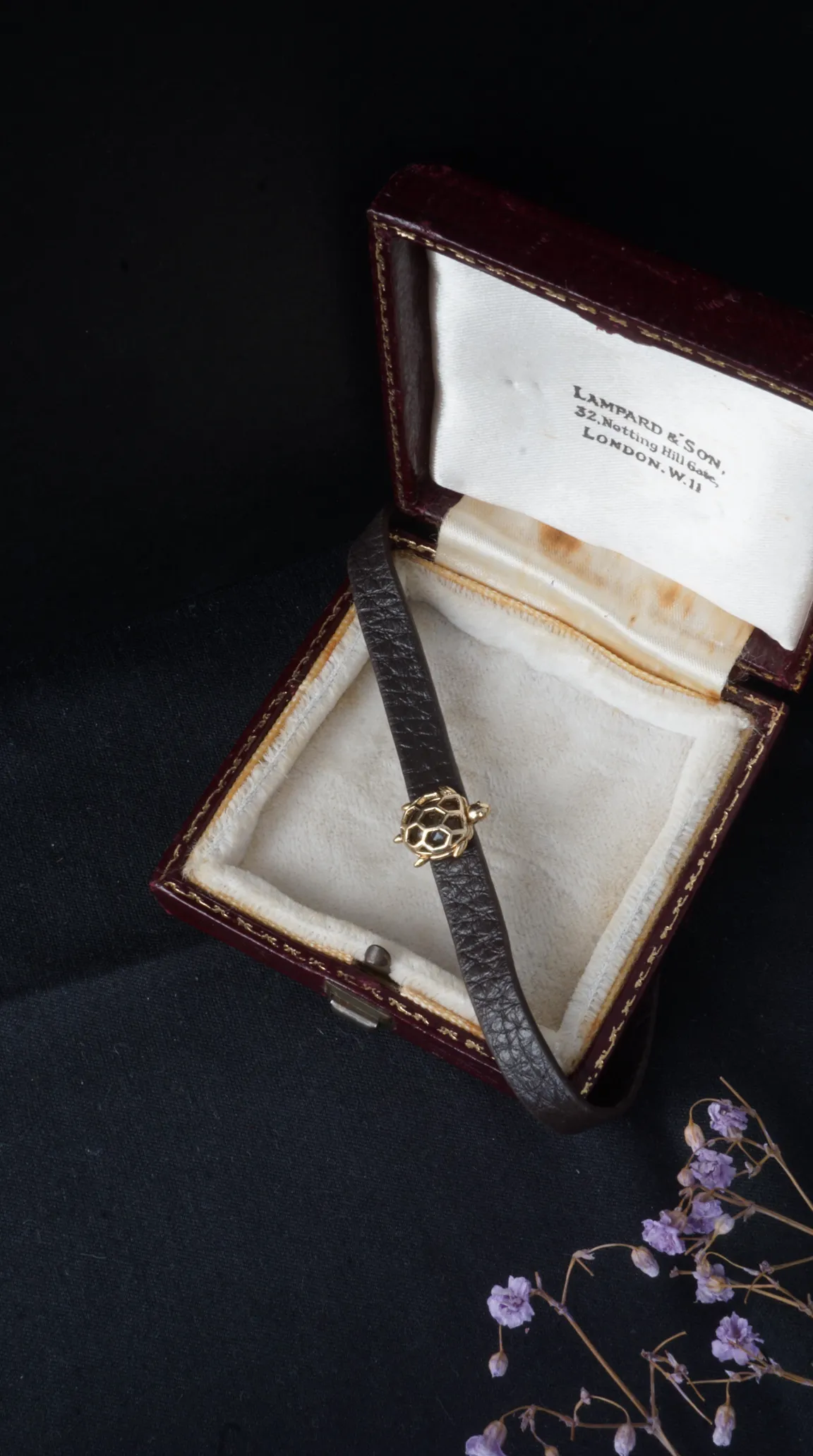 Vintage dark brown leather bracelet with gold turtle charm, in antique Lampard & Son London jewelry box.