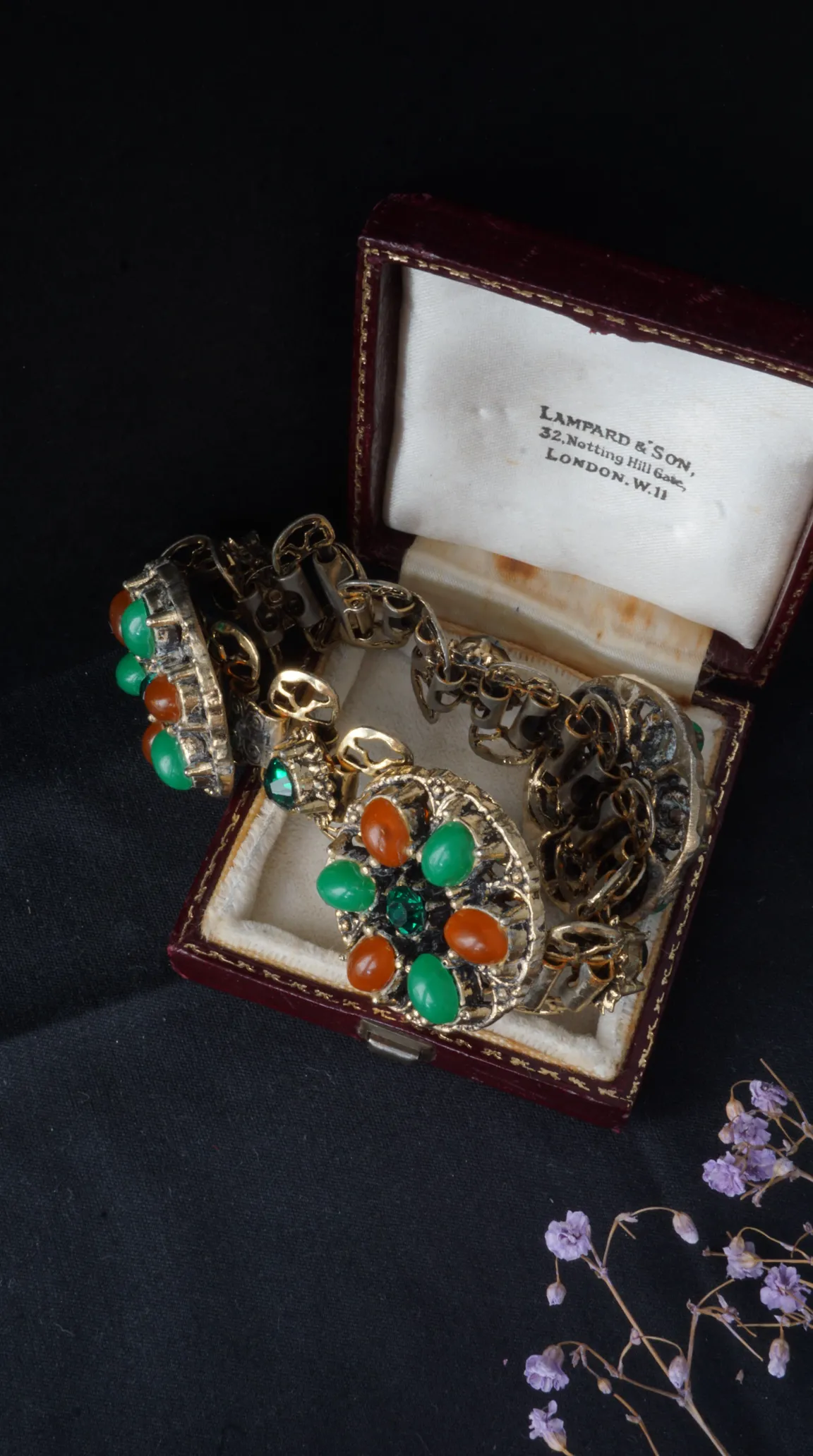 Vintage gold tone bracelet with green and orange cabochon gemstones in a red Lampard & Son jewelry box