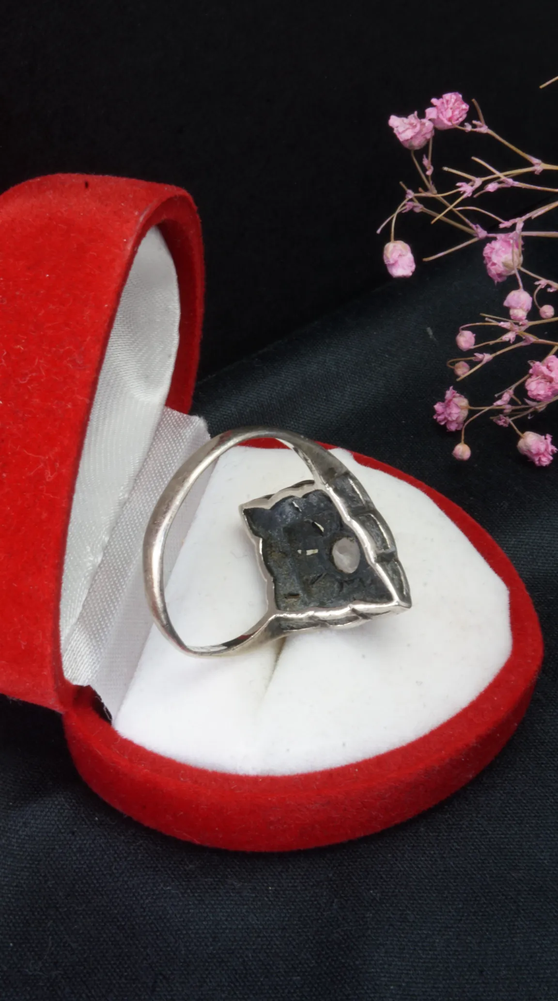 Vintage silver geometric ring with Art Deco style setting and light gemstone, in a red velvet heart-shaped box.