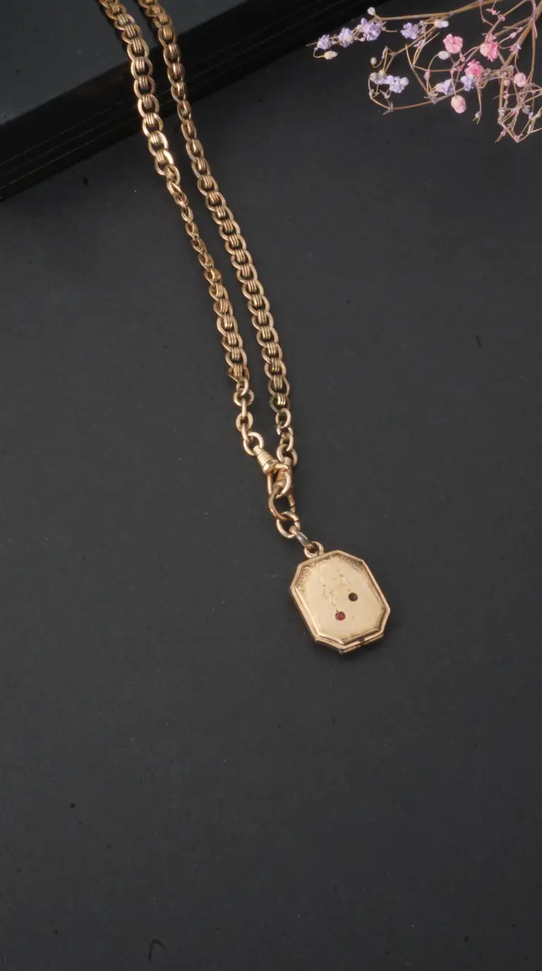 Vintage gold ornate chain necklace with octagonal locket, engraved details, and red and black accents.