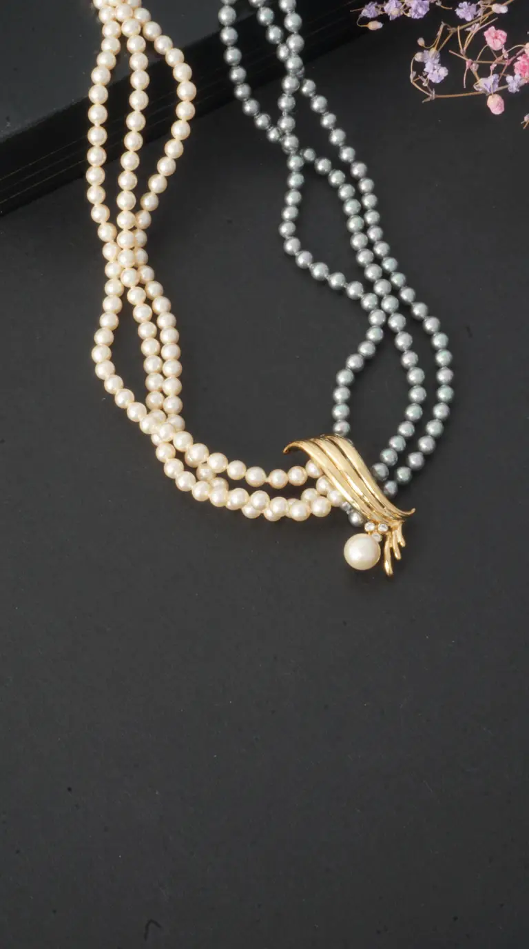 Vintage multi-strand pearl necklace with cream and grey pearls, featuring an ornate gold-tone clasp with sparkling rhinestone accents and a pearl drop.
