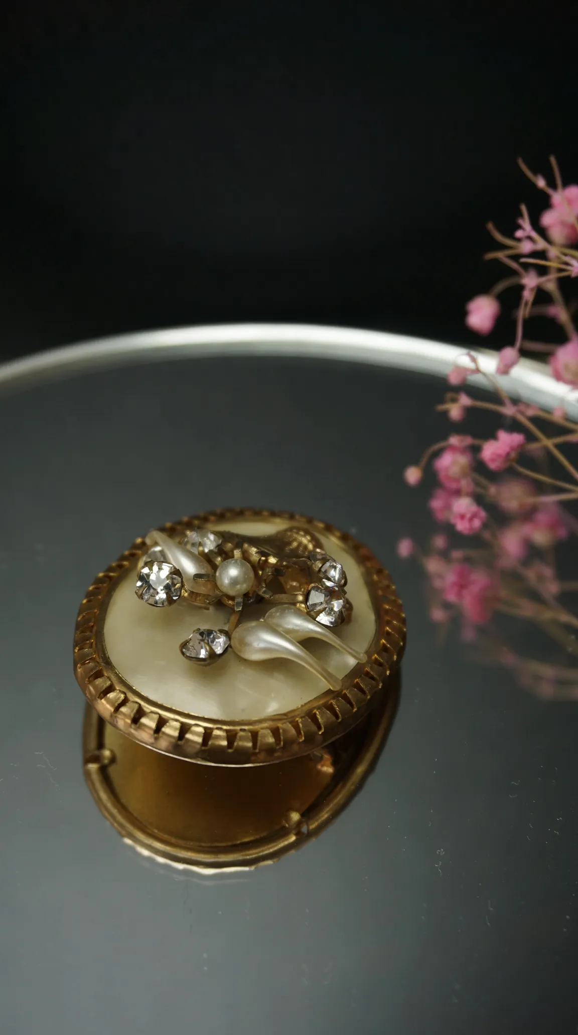 Vintage gold tone pillbox with mother of pearl, rhinestone, and faux pearl accents.
