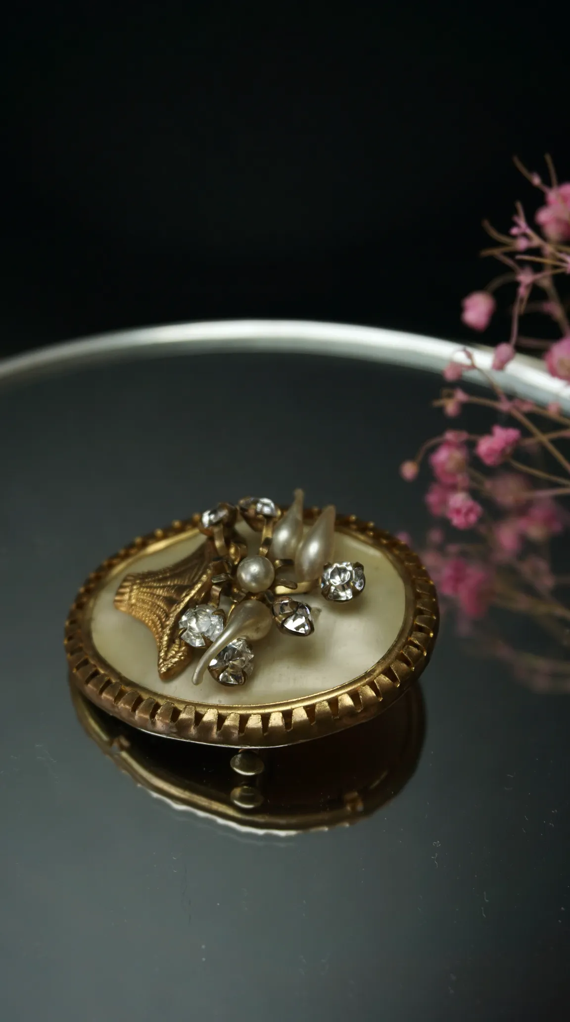 Vintage oval gold-toned brooch with cream mother-of-pearl base, faux pearls, sparkling rhinestones, and a textured gold leaf design.