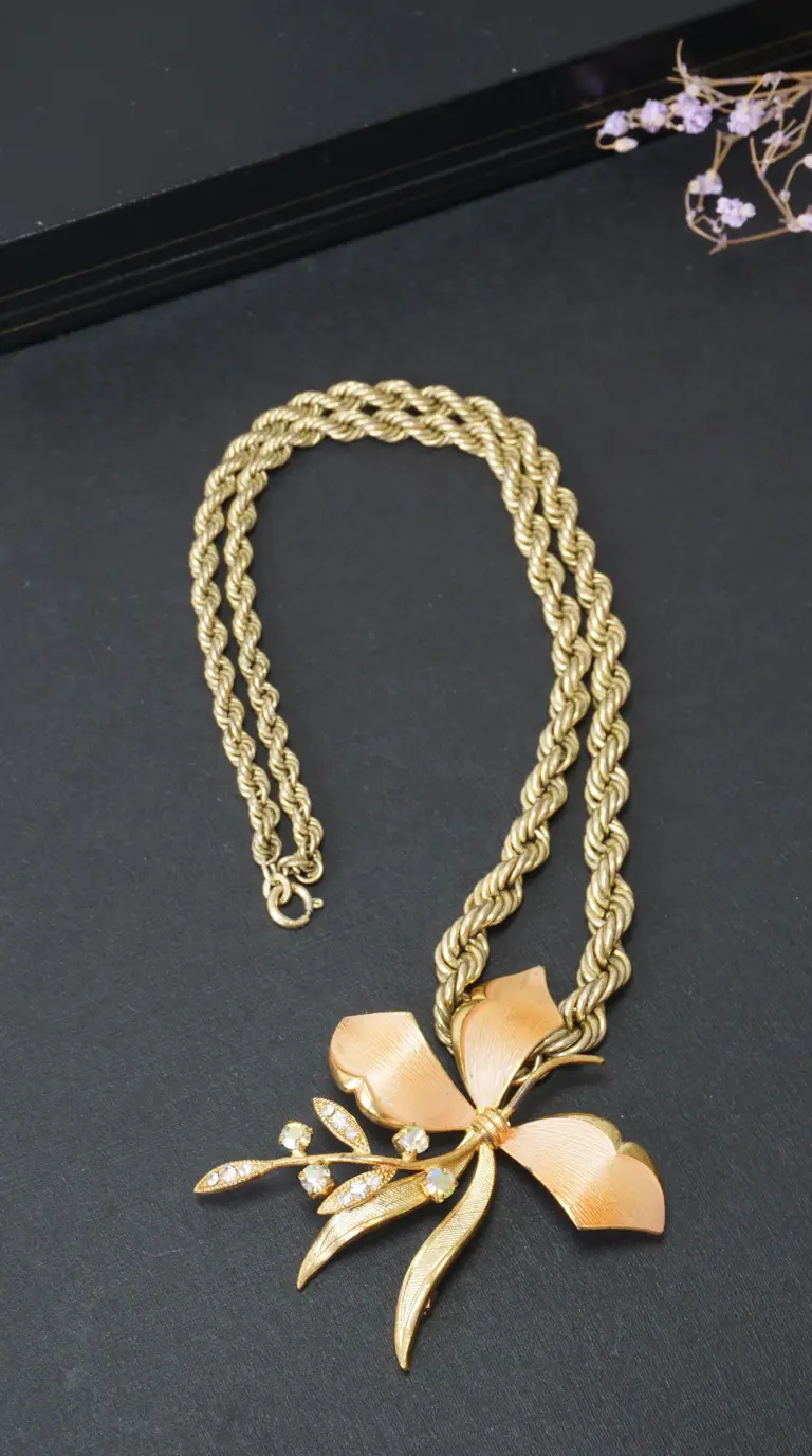 Vintage gold tone double rope chain necklace with peach enamel floral pendant and clear rhinestone accents