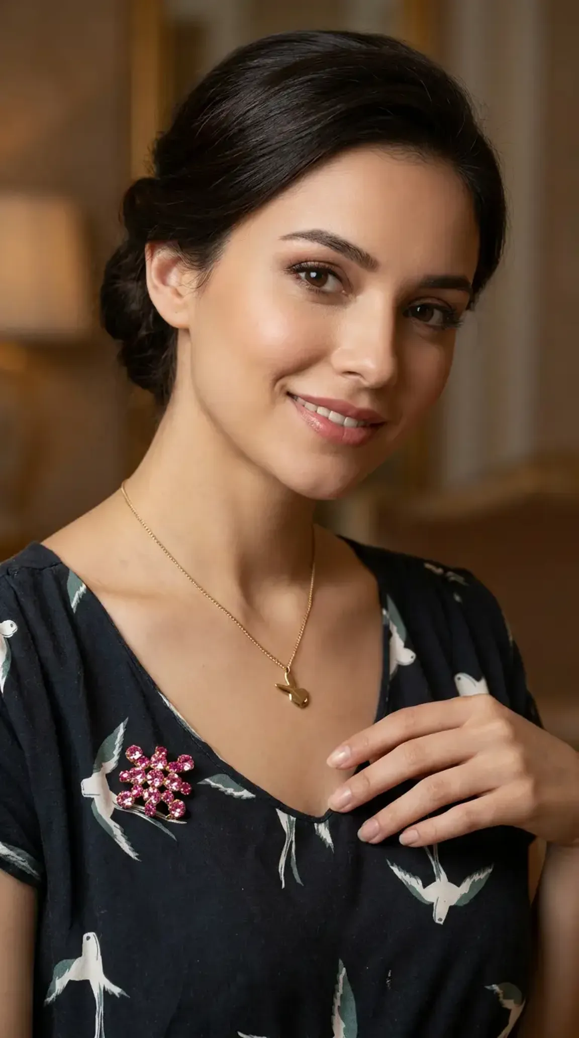 Vintage gold necklace with pink crystal cluster pendant worn by a woman.