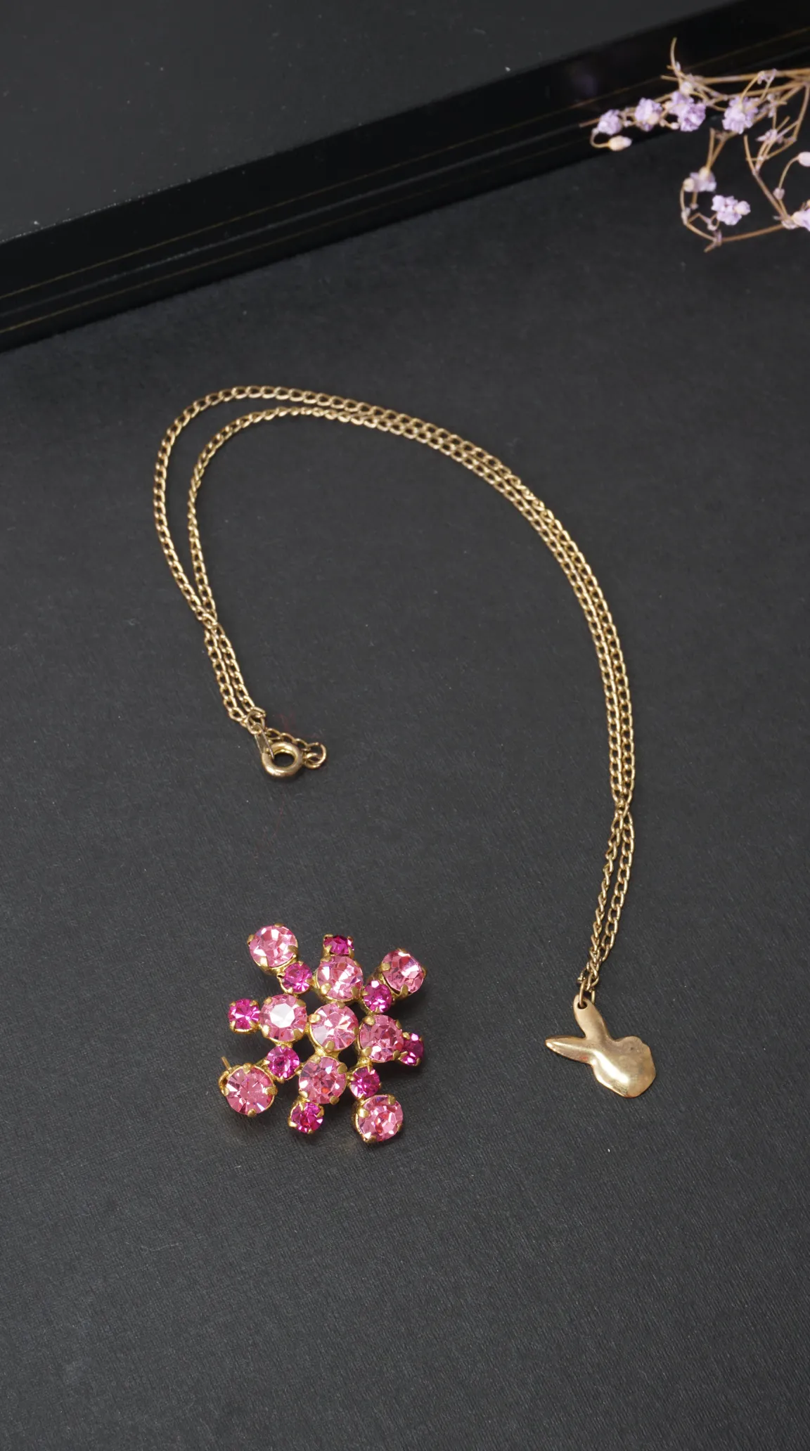 Vintage gold-tone bunny charm necklace and pink rhinestone flower brooch.