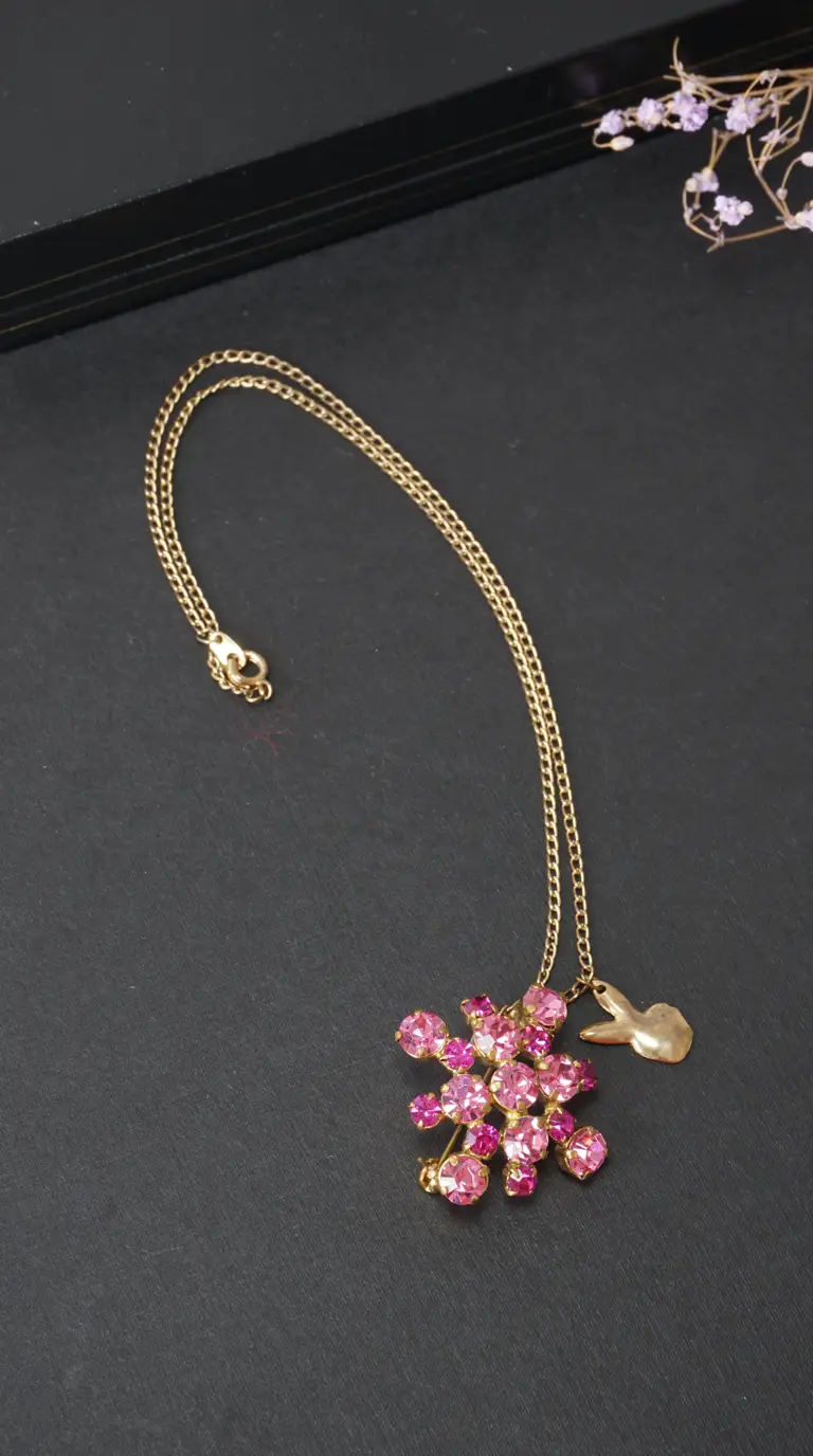 Vintage gold chain necklace with pink rhinestone cluster pendant and gold bunny charm.