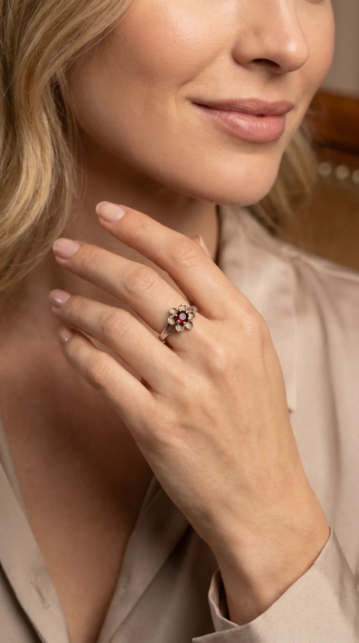 Vintage silver flower ring with red garnet gemstone on woman's hand
