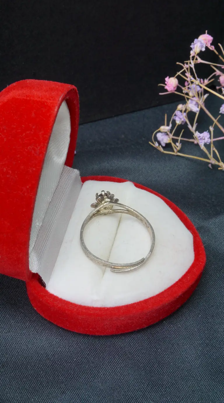 Vintage silver adjustable ring with dark gemstone in red heart-shaped velvet box
