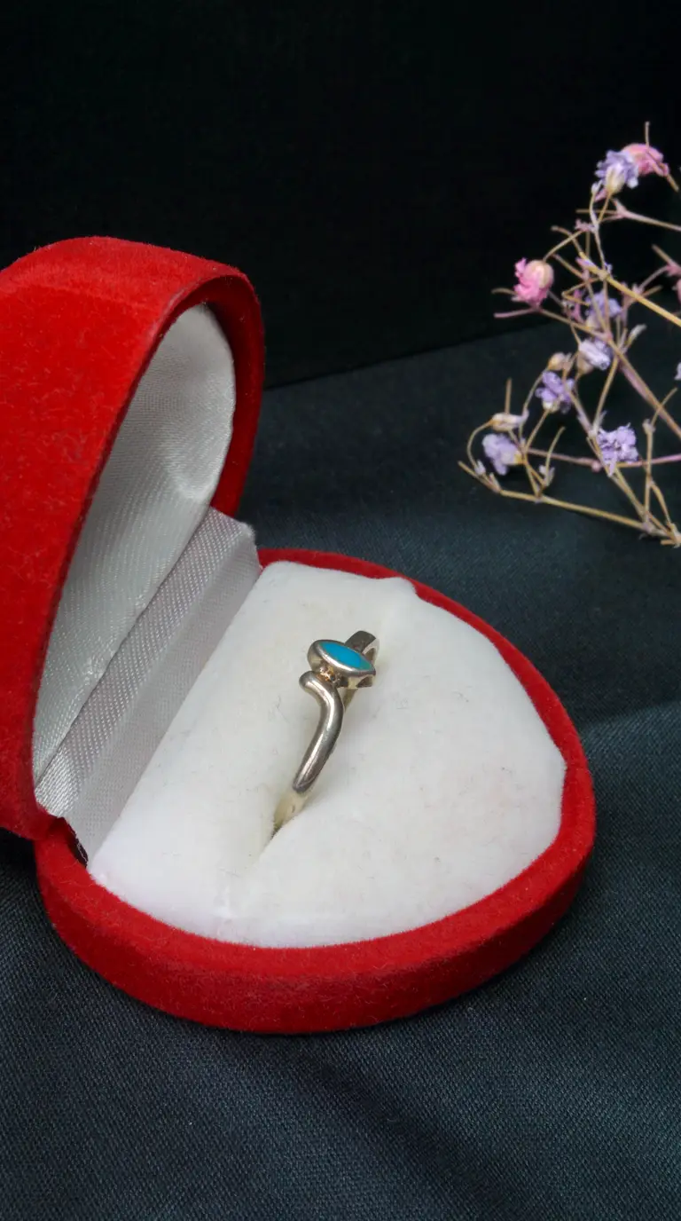 Vintage sterling silver ring with oval turquoise gemstone in red velvet heart-shaped box.