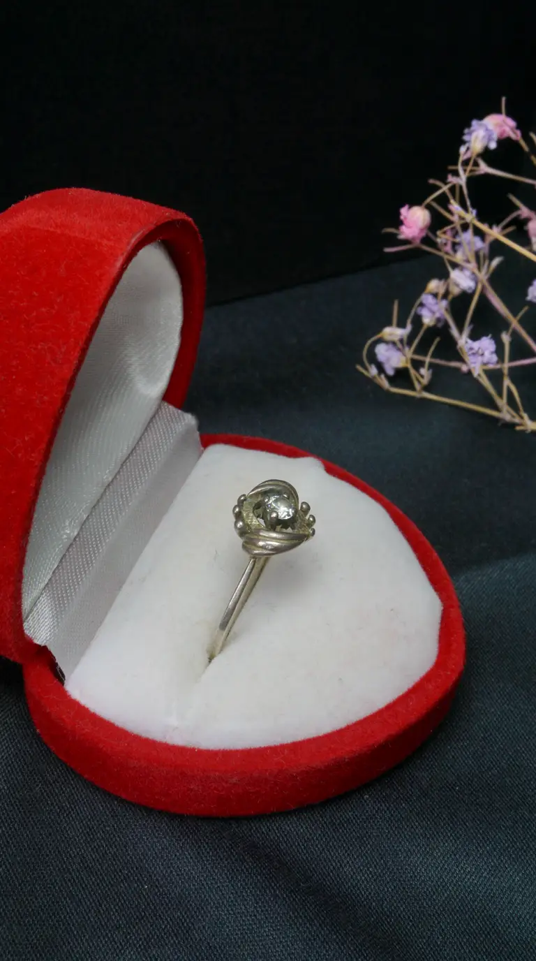 Vintage sterling silver ring with clear gemstone, ornate beaded setting, red velvet jewelry box, antique collectible.