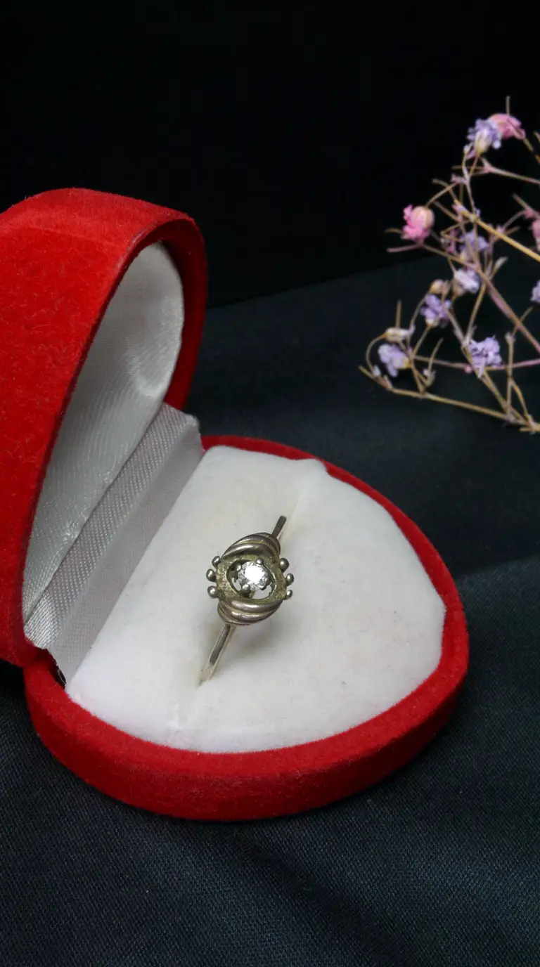 Vintage sterling silver ring with clear gemstone in open red velvet box