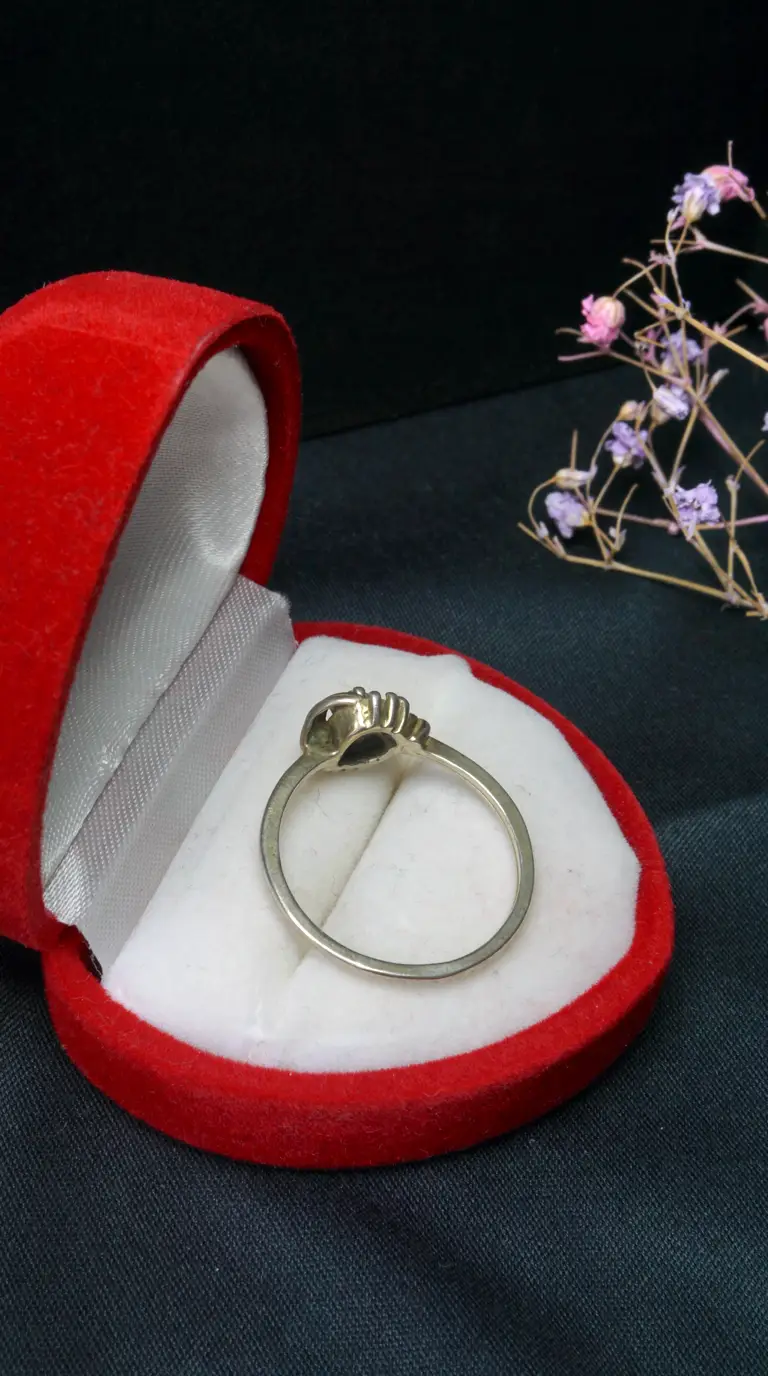 Vintage silver ring with dark gemstone in red velvet heart-shaped box