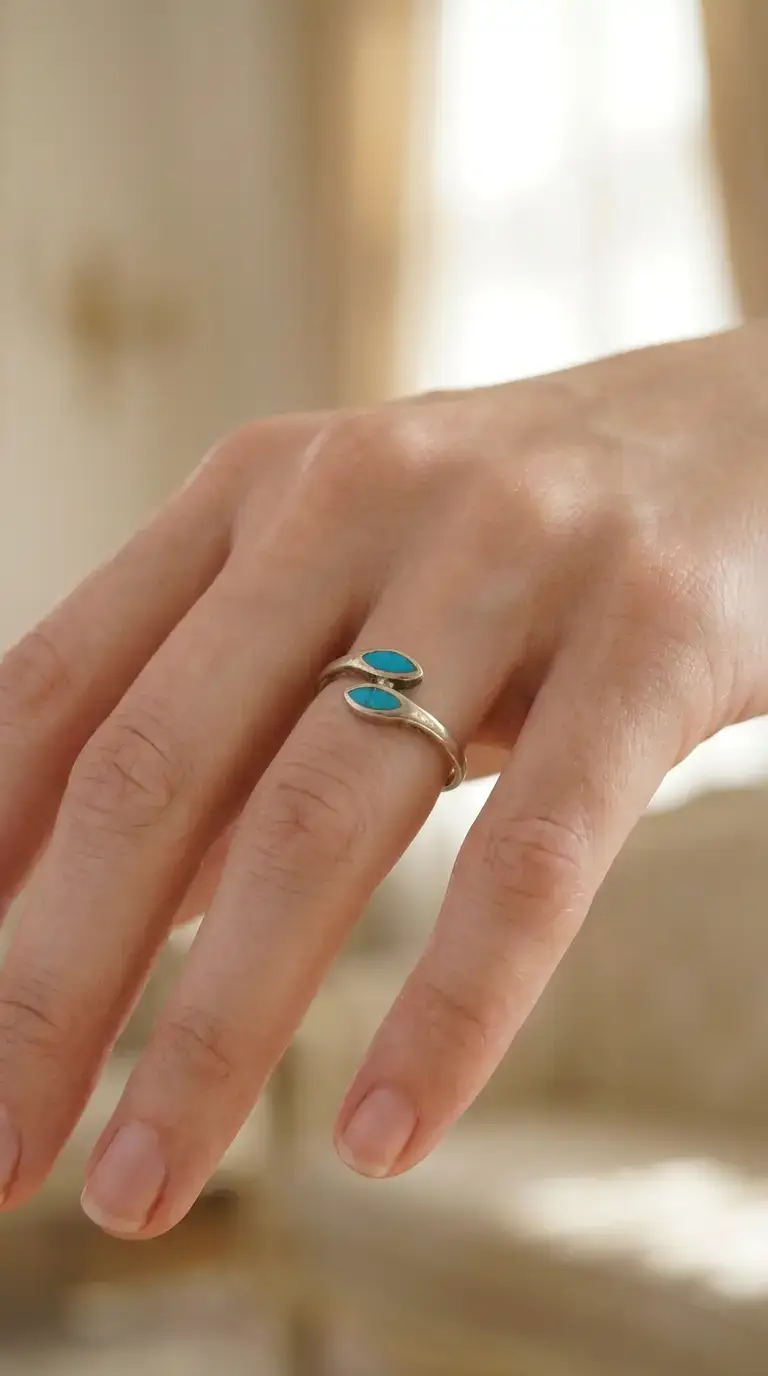 Vintage sterling silver bypass ring with two vibrant turquoise teardrop stones on a hand