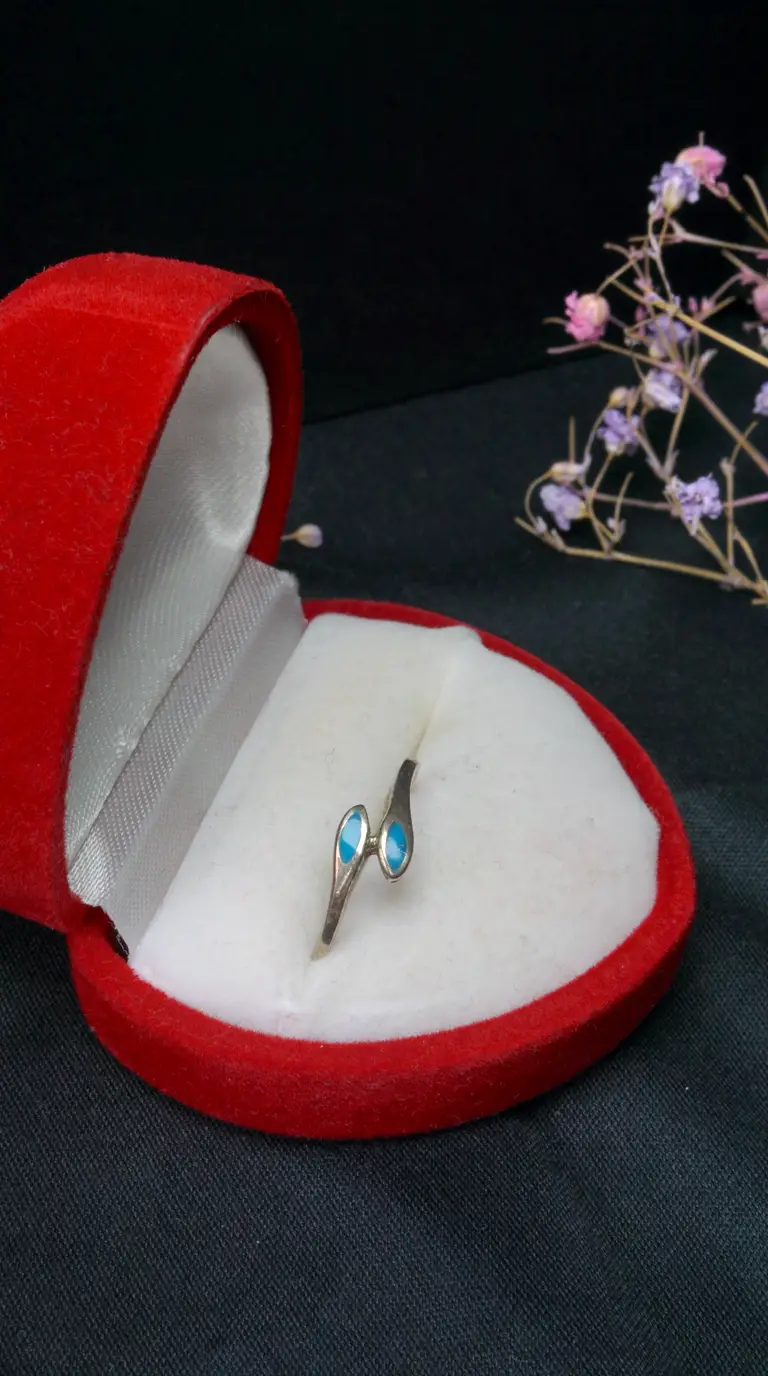 Vintage sterling silver bypass ring with turquoise stones in open red velvet heart box.