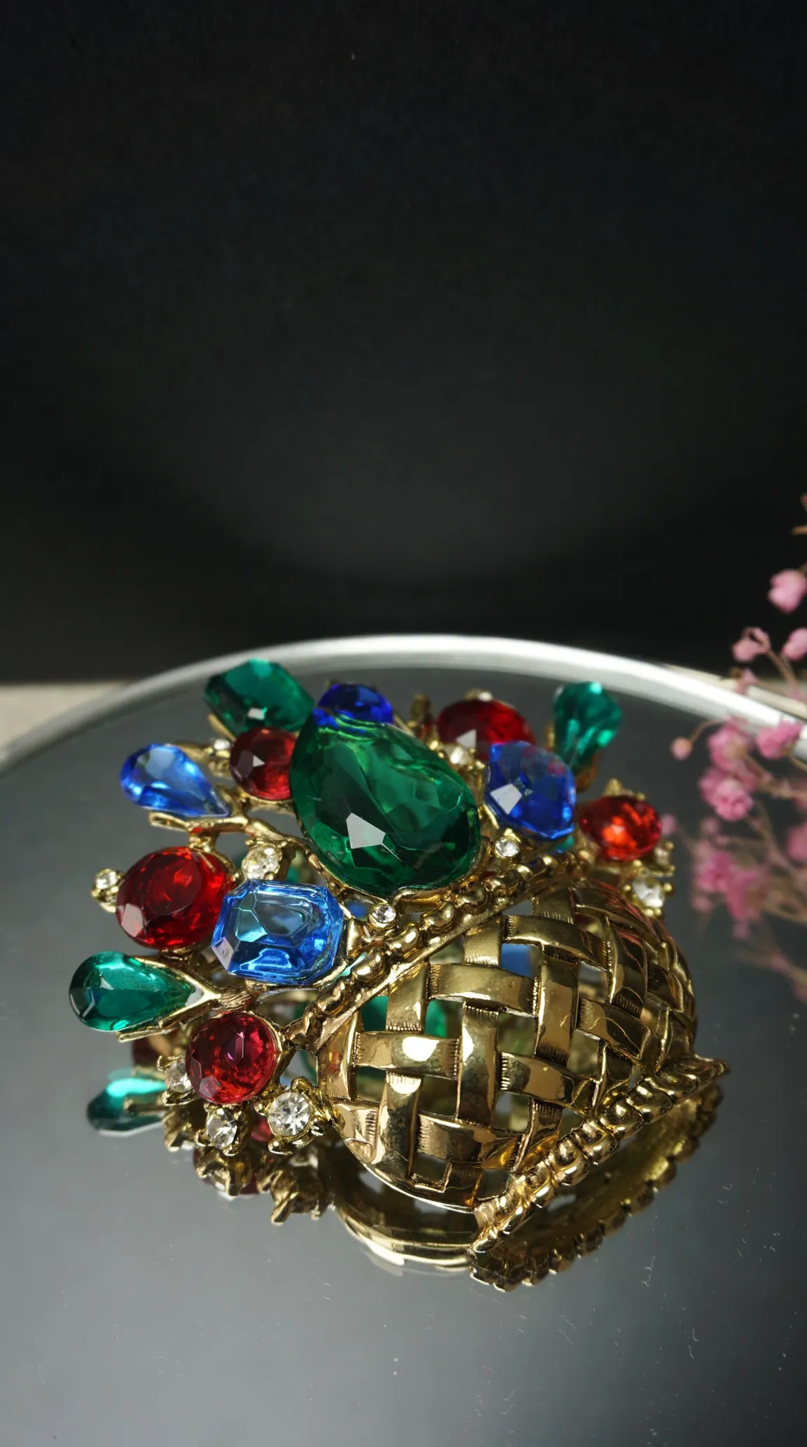 Vintage gold tone basket weave brooch with large faceted emerald green, ruby red, and sapphire blue crystal jewels, accented with clear rhinestones.