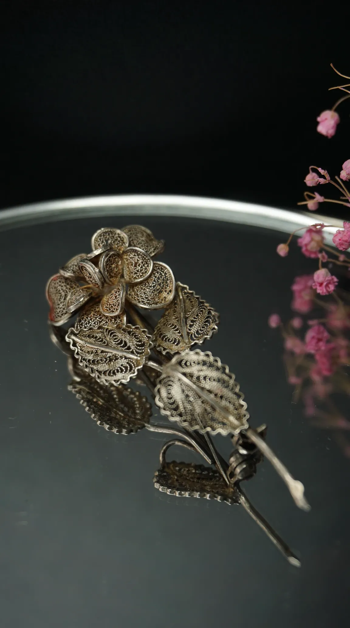 Vintage silver filigree floral brooch with intricate flower and leaf design for antique jewelry collectors.