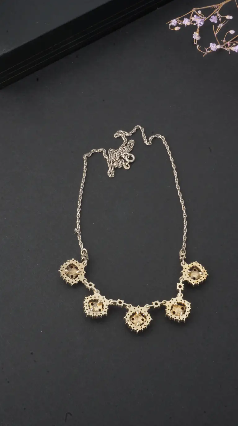 Vintage silver rope chain necklace with five square gold-tone pendants set with light brown gemstones and clear crystals.