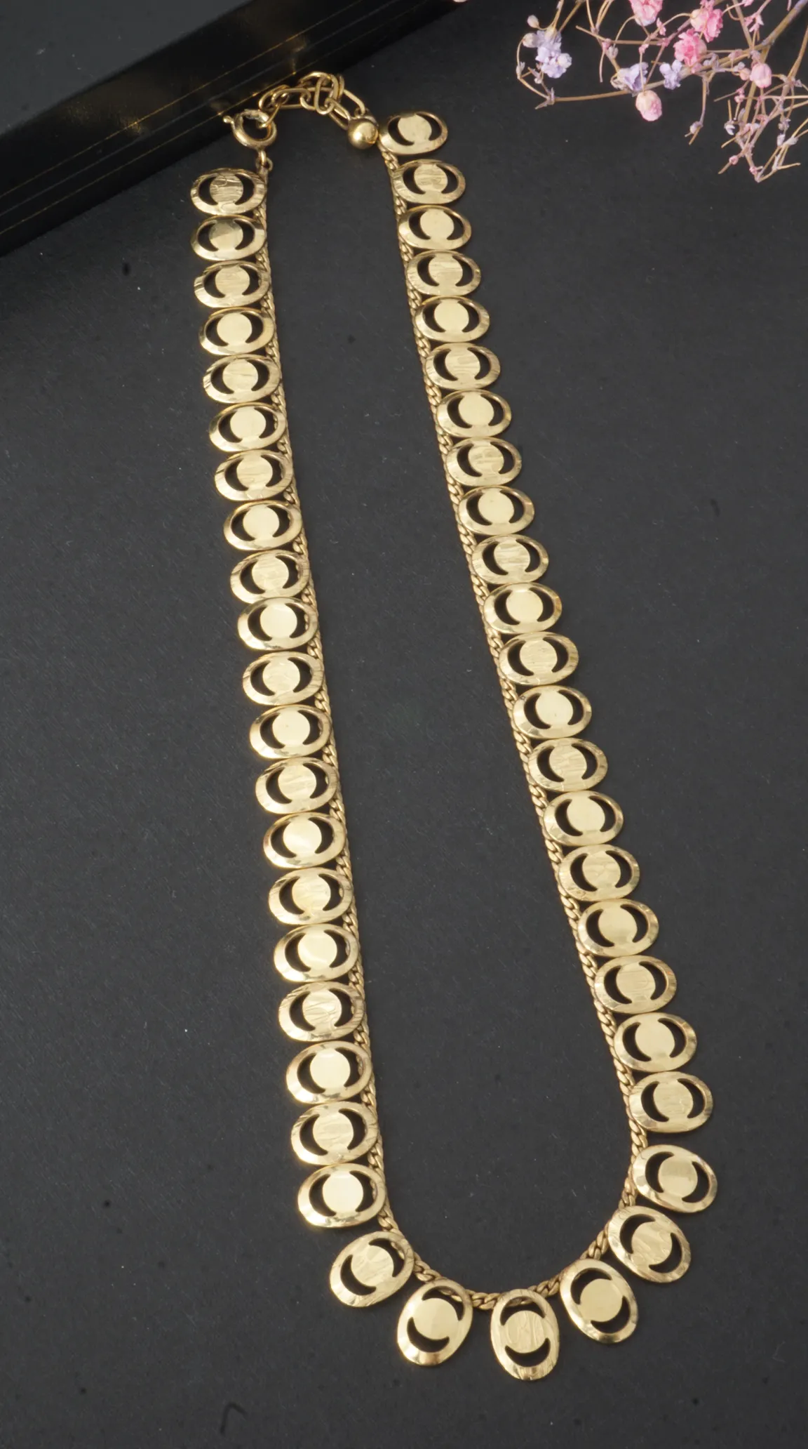 Vintage gold necklace with flat oval links and etched geometric patterns